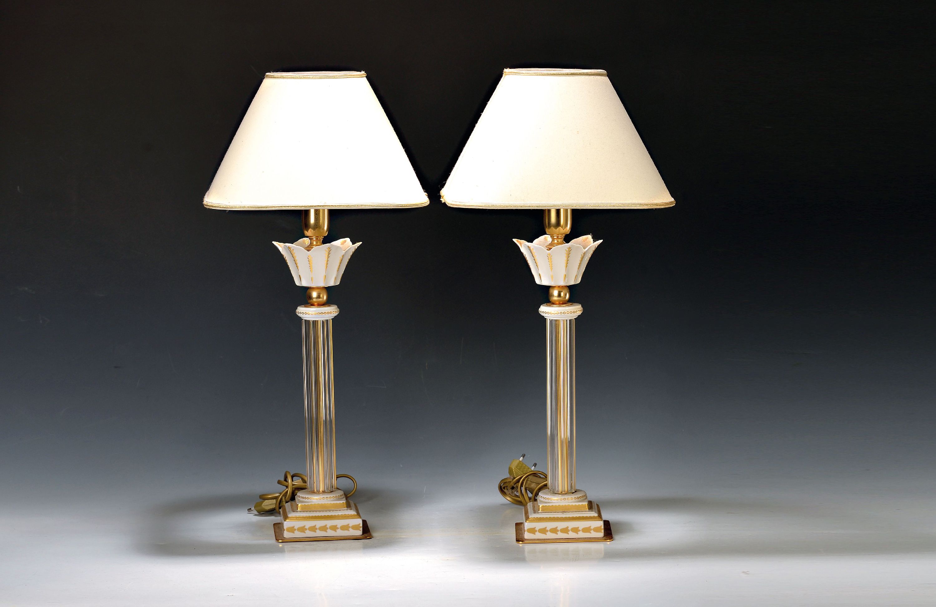 Paar Tischlampen, Giulia Mangani, Florenz, 2. Hälfte 20.Jh., Fuß und blütenförmige Tülle aus Porzellan, goldstaffiert, Glasschaft, H. 42 cm, ...