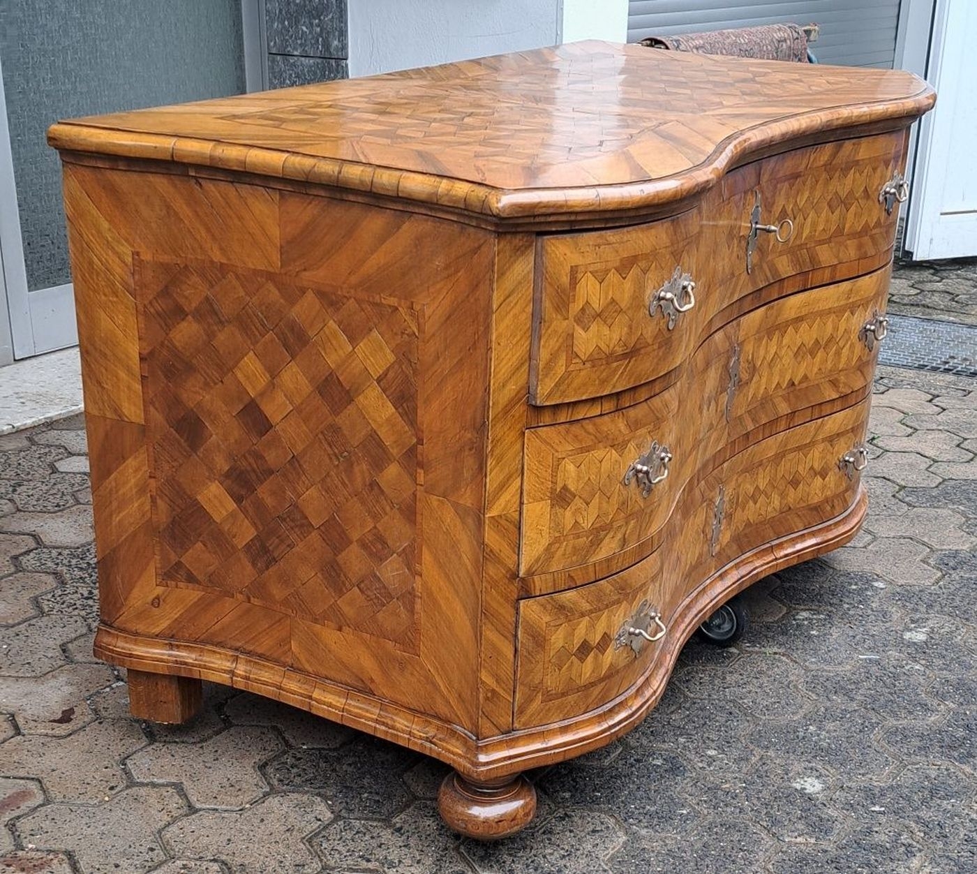 Detail a: Barock Kommode, um 1740/50, Nußbaumfurnier, 3 Schubladen, doppelt geschweift, Front, Deckplatte und Seiten mit Würfelmarketerie, Messingbeschläge, ...