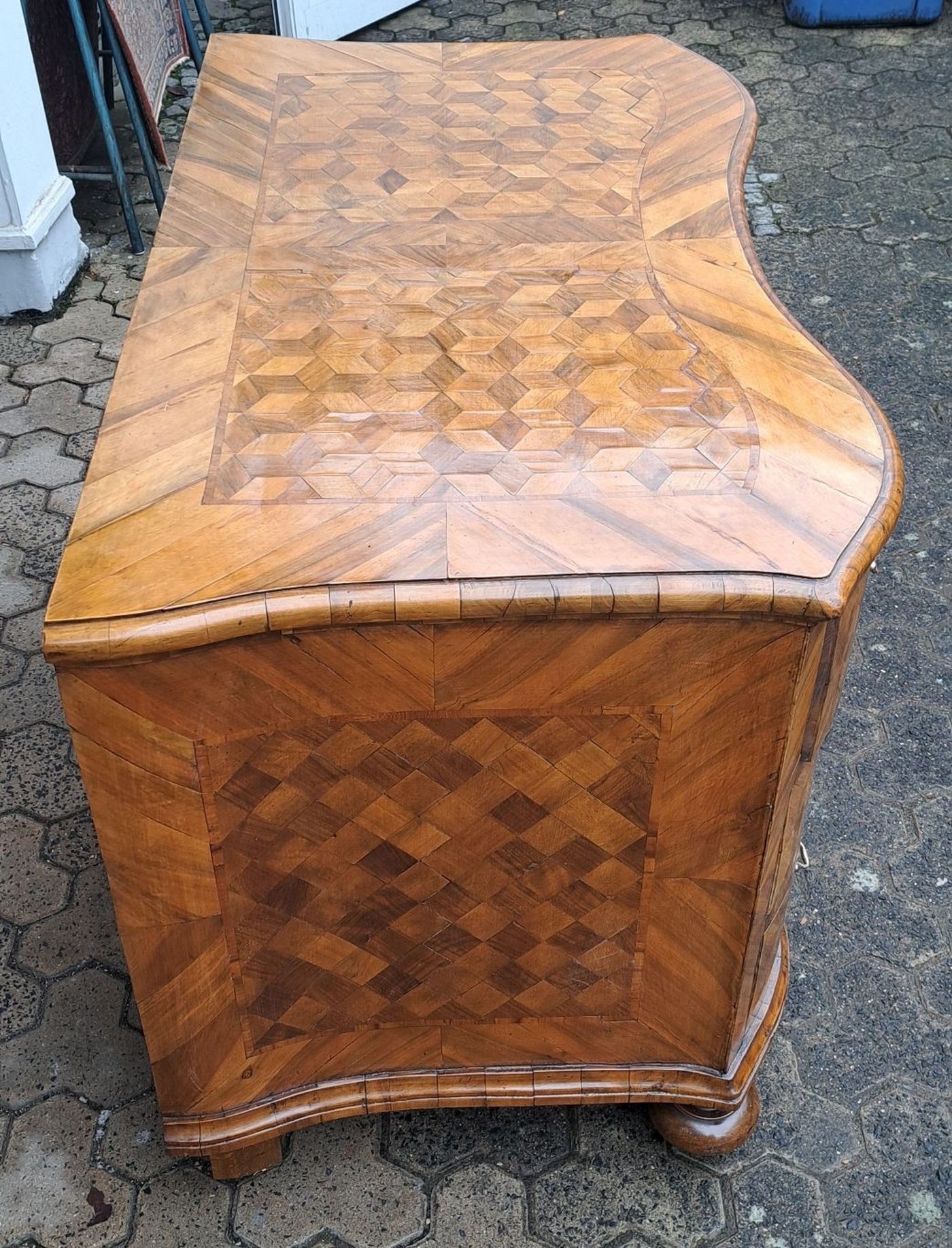 Detail b: Barock Kommode, um 1740/50, Nußbaumfurnier, 3 Schubladen, doppelt geschweift, Front, Deckplatte und Seiten mit Würfelmarketerie, Messingbeschläge, ...