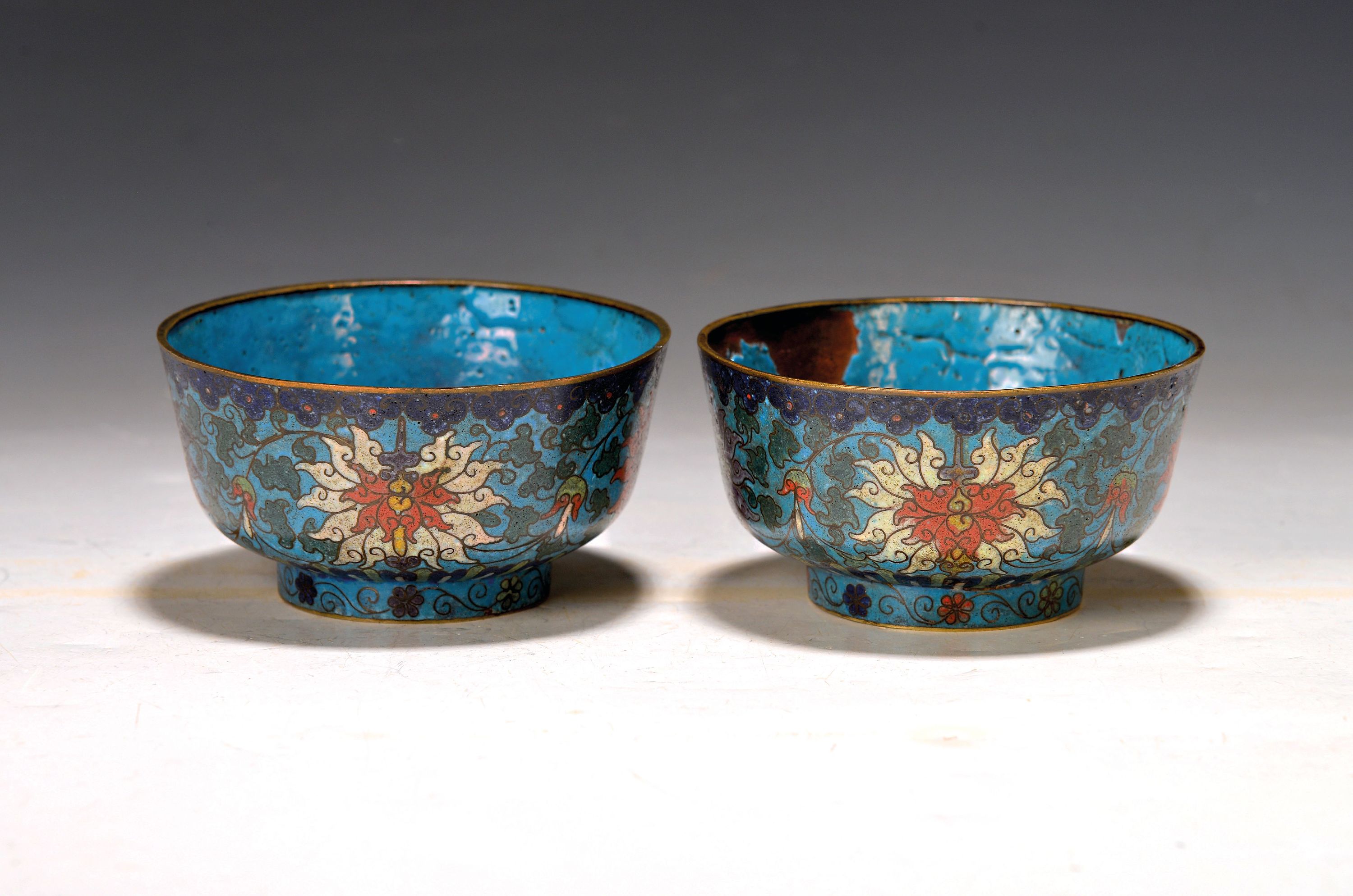 Zwei Cloisonne-Schalen, China um 1880/90, blaugrundig mit buntem Blumendekor, innen blau, eine Schale innen mit Ausbruch und l. rissig, Altersspuren, ...