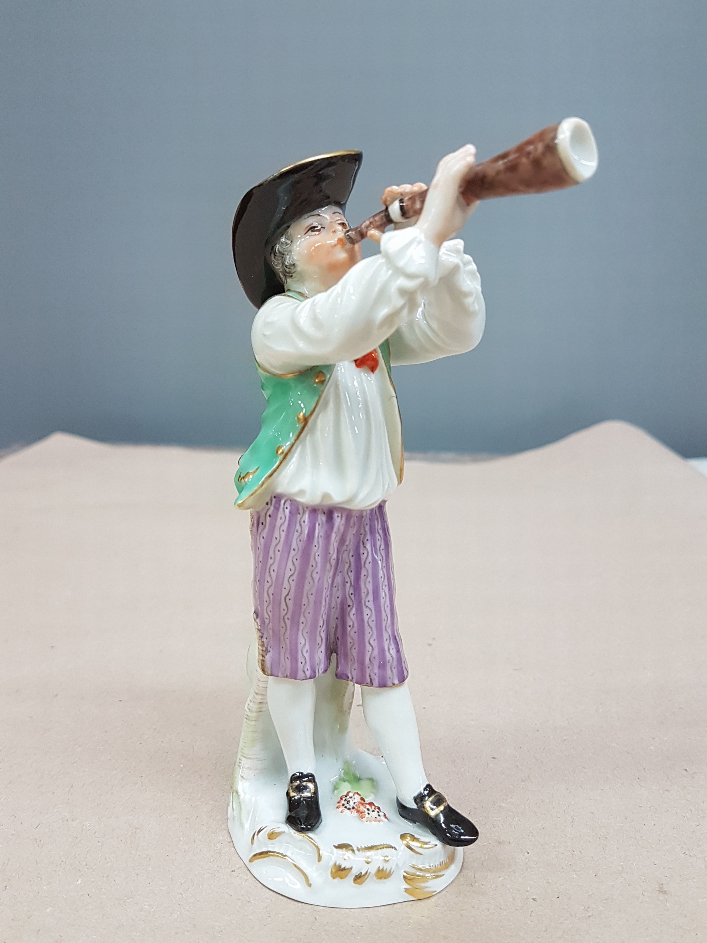 Detail a: Porzellanfigur, Meissen, 20. Jh., Entwurf Johann Joachim Kaendler, aus der Serie Cris de Paris, Ausrufer mit Horn, bunt bemalt, Goldstaffage, H. ca. ...