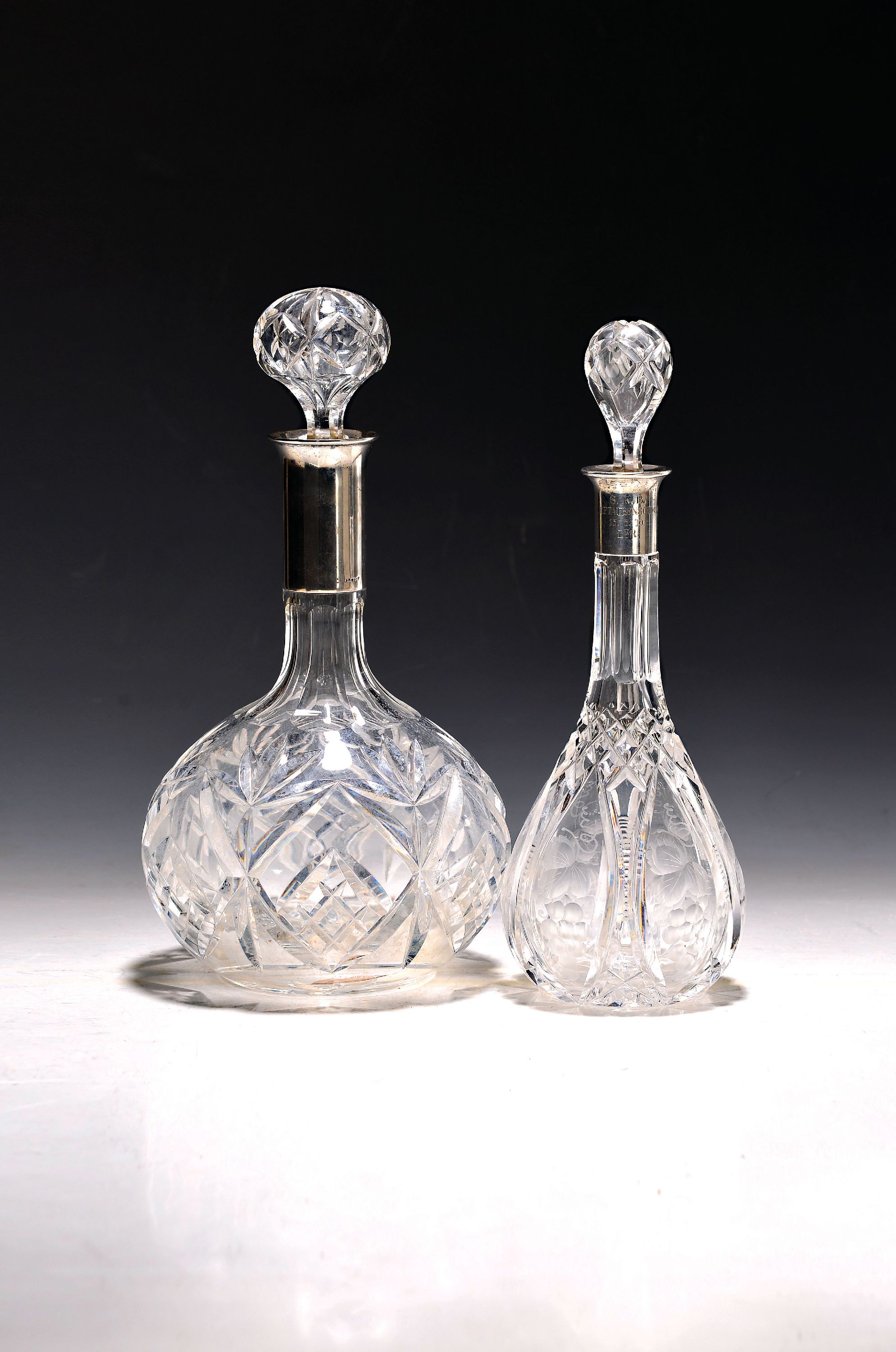 Zwei Karaffen, deutsch, Anfang 20.Jh., Glaskorpi geschliffen, Silbermonturen, orig. Stopfen, H.28/26 cm, Kleinere bestoßen und mitGravur: S.K.B. ...