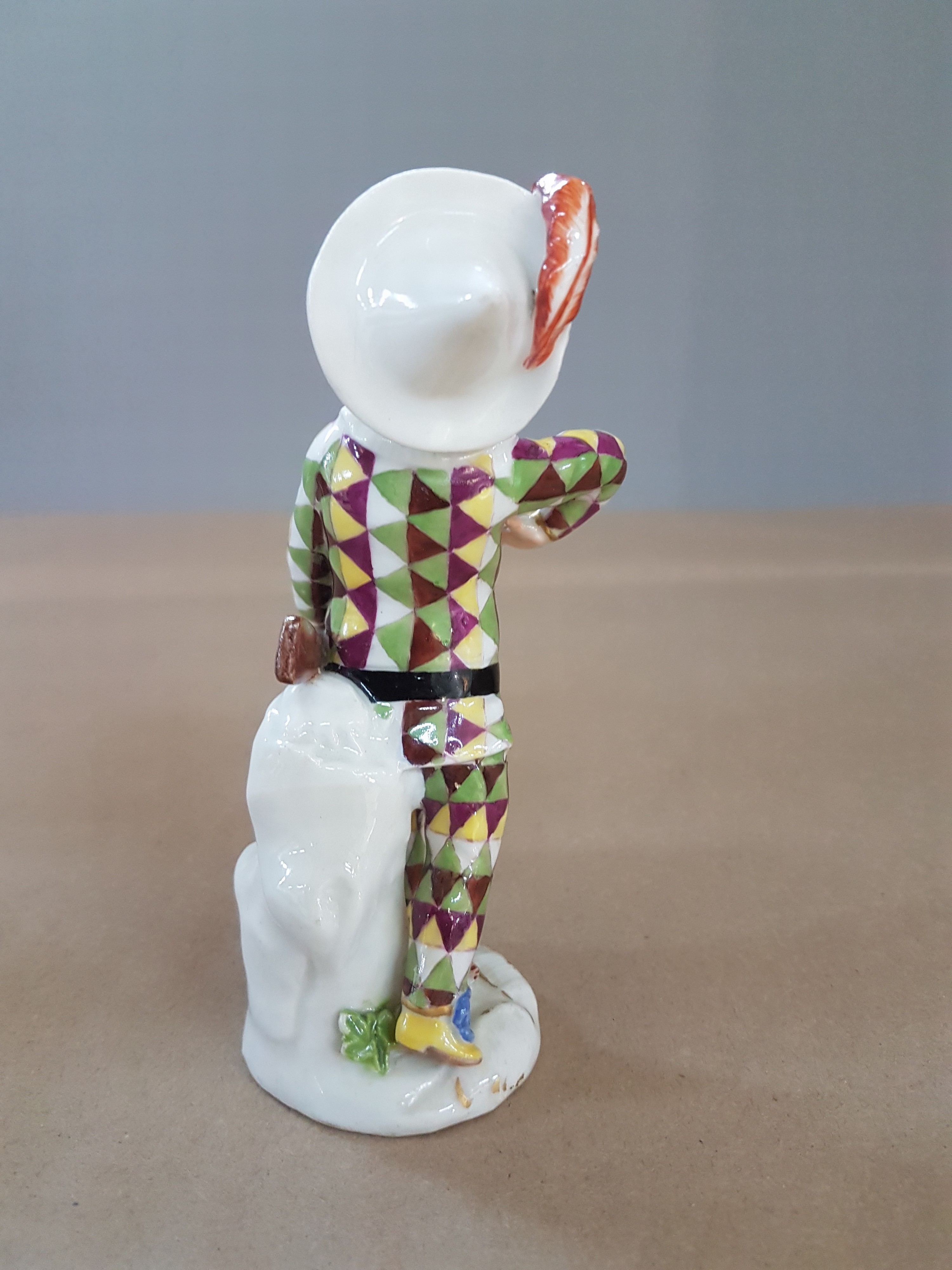 Detail b: Porzellanfigur, Meissen, um 1750, kleiner Harlekin, Porzellan, polychrom bemalt, Goldstaffage, restauriert, Reste von Reste von Schwertermarke auf ...