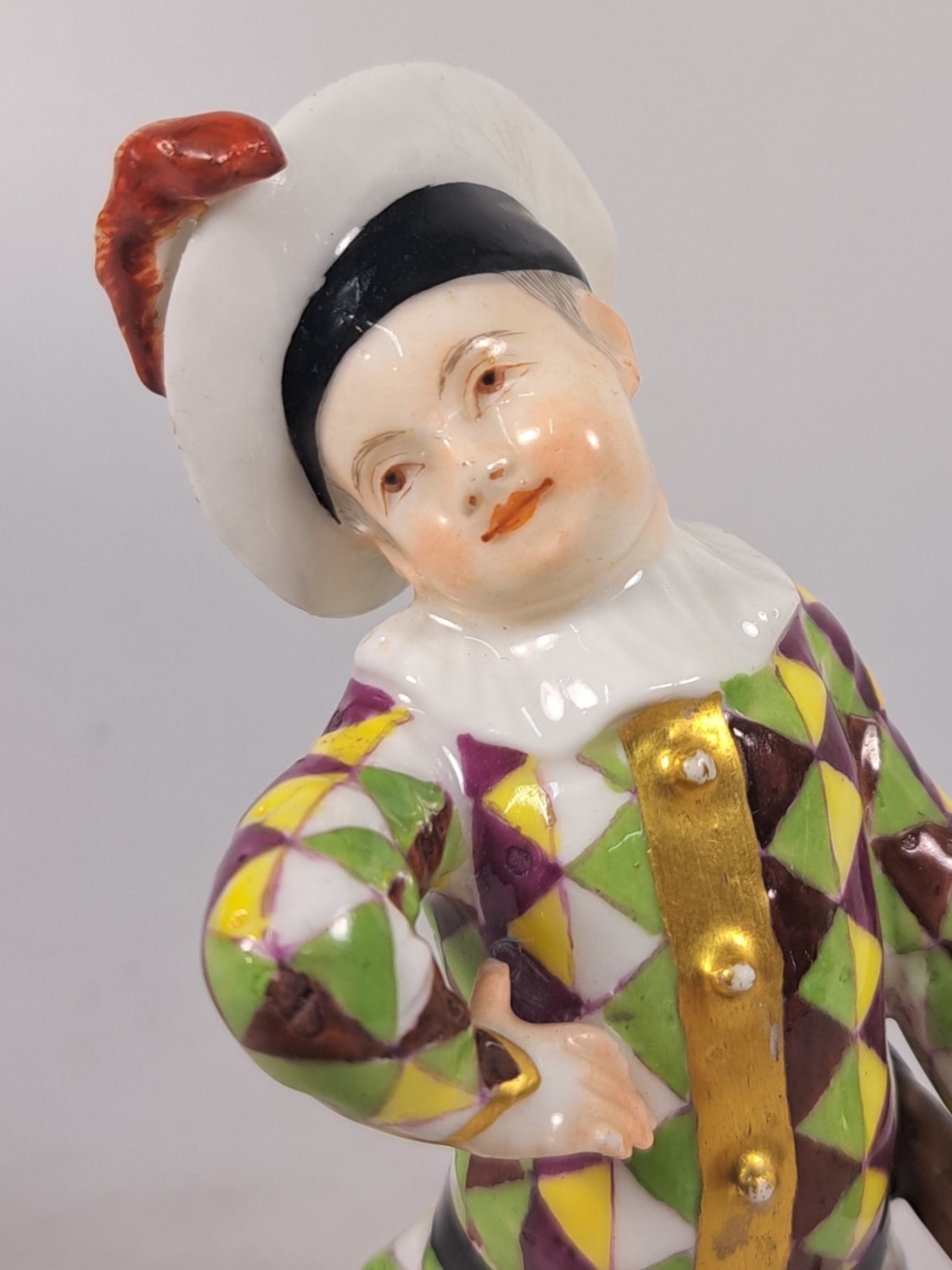 Detail g: Porzellanfigur, Meissen, um 1750, kleiner Harlekin, Porzellan, polychrom bemalt, Goldstaffage, restauriert, Reste von Reste von Schwertermarke auf ...