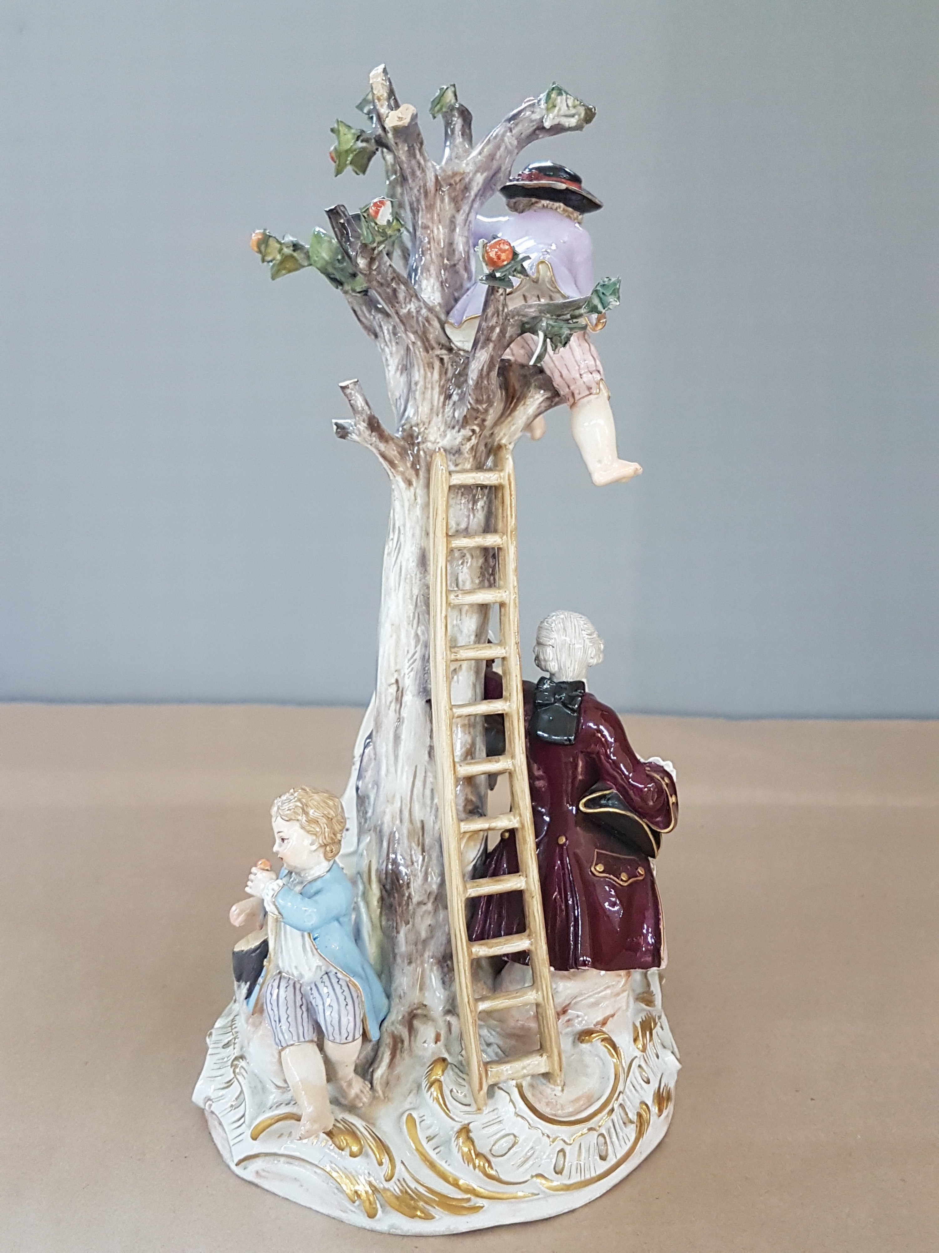 Detail d: Porzellangruppe, Meissen, um 1850-1924, Apfelernte, galantes Paar und zwei Knaben bei der Ernte, rest., bestoßen bzw. Fehlstellen im Baum, polychrom ...