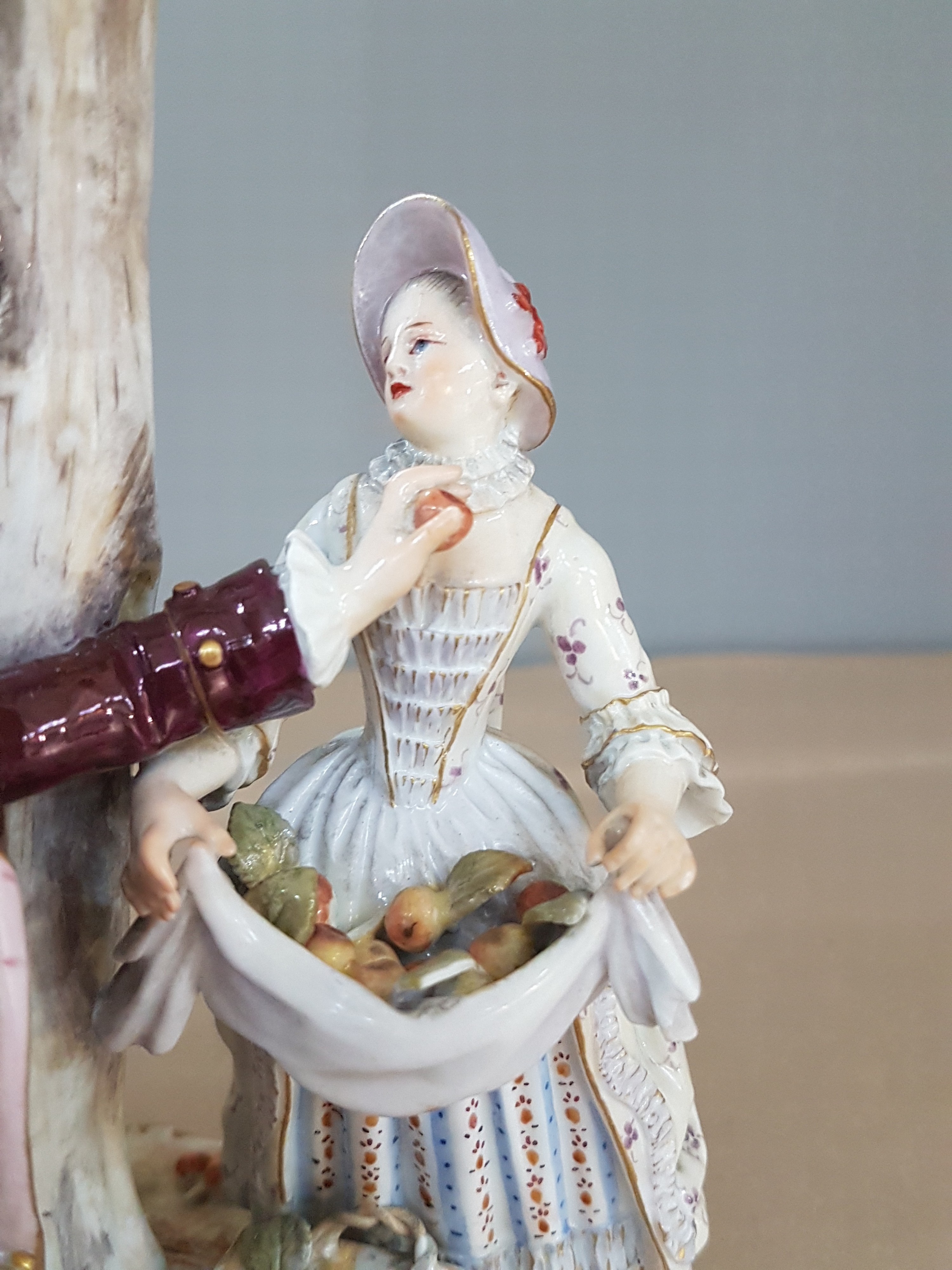Detail e: Porzellangruppe, Meissen, um 1850-1924, Apfelernte, galantes Paar und zwei Knaben bei der Ernte, rest., bestoßen bzw. Fehlstellen im Baum, polychrom ...