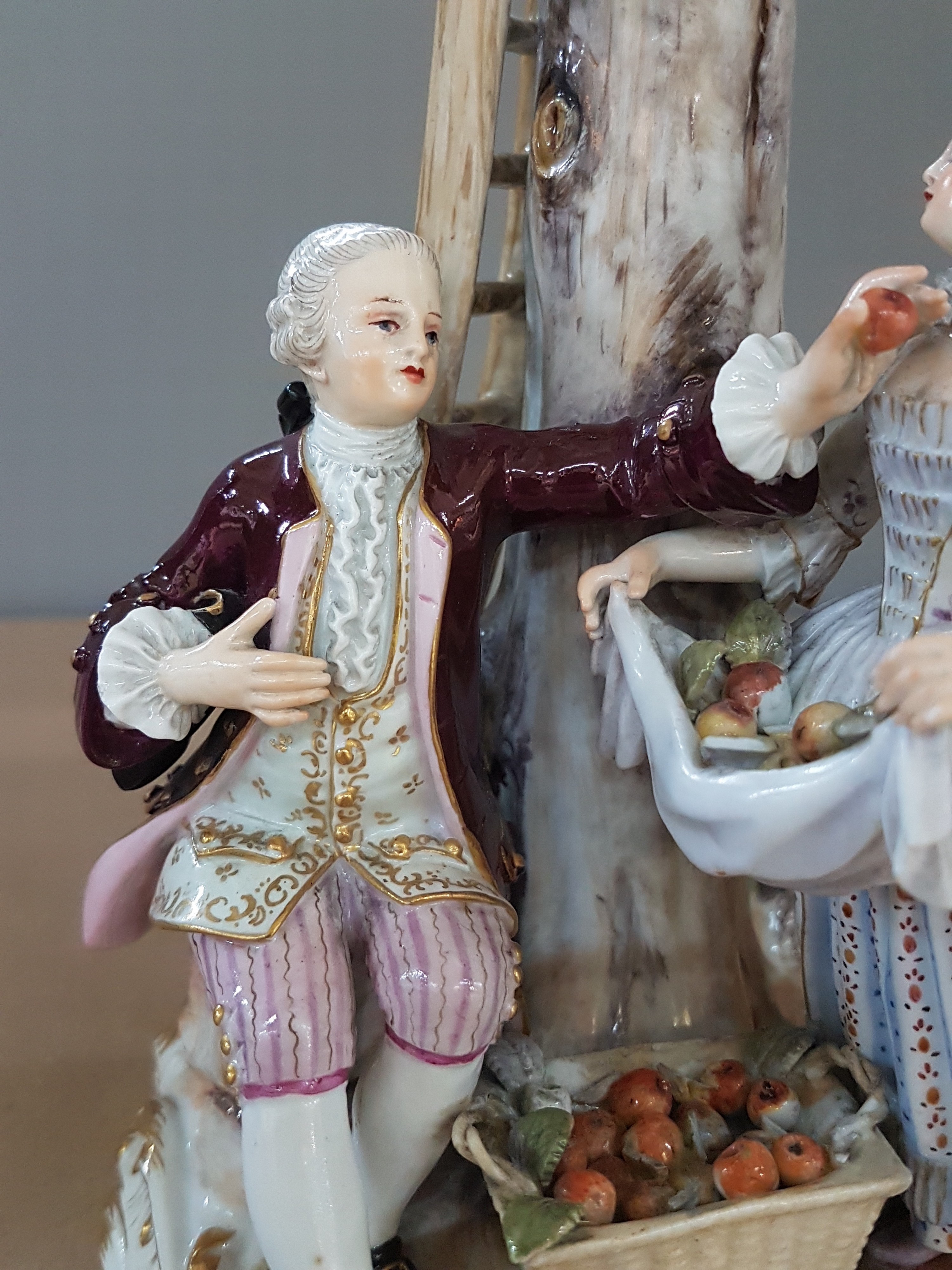 Detail f: Porzellangruppe, Meissen, um 1850-1924, Apfelernte, galantes Paar und zwei Knaben bei der Ernte, rest., bestoßen bzw. Fehlstellen im Baum, polychrom ...