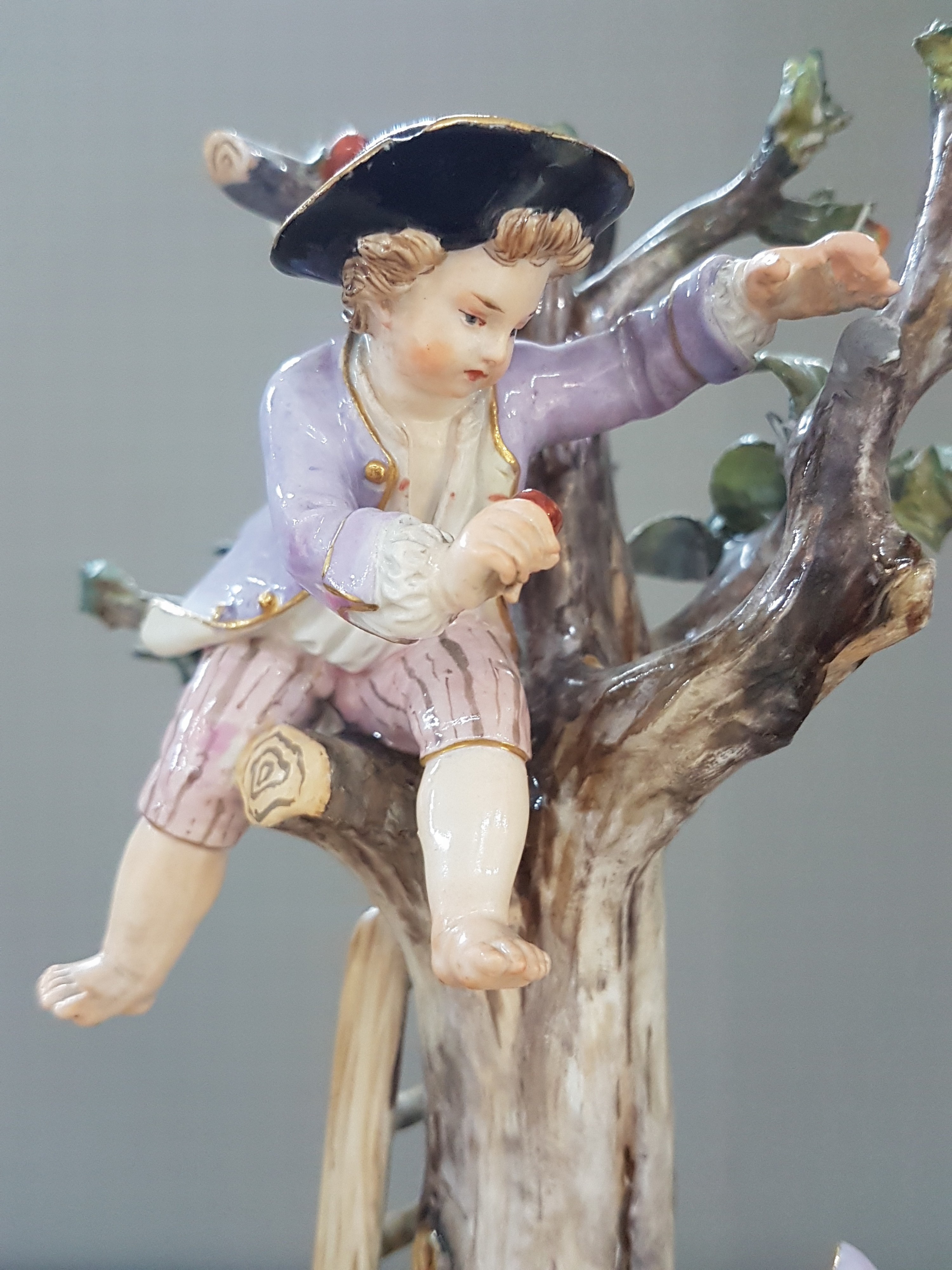 Detail g: Porzellangruppe, Meissen, um 1850-1924, Apfelernte, galantes Paar und zwei Knaben bei der Ernte, rest., bestoßen bzw. Fehlstellen im Baum, polychrom ...