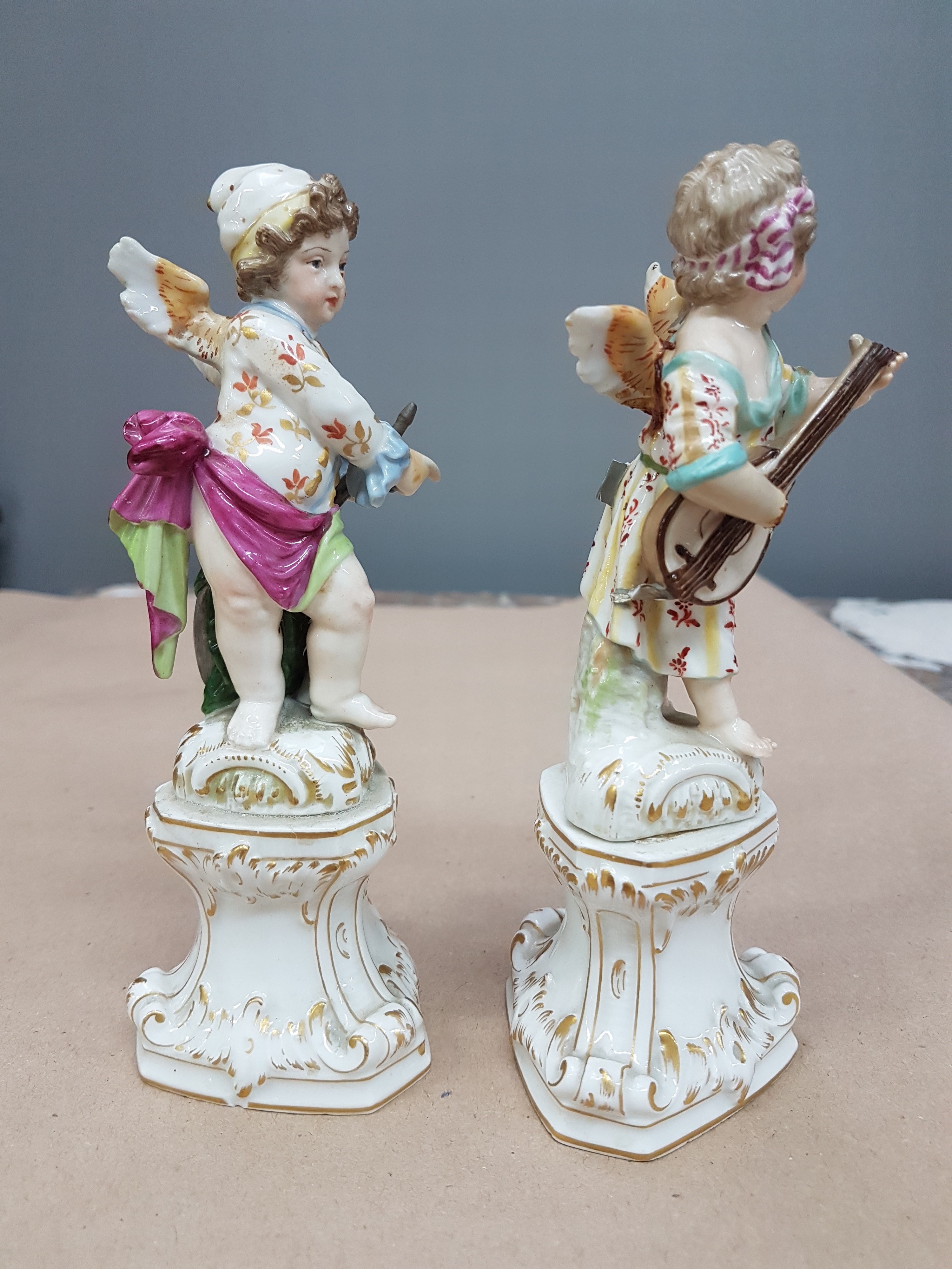 Detail d: Paar Porzellanfiguren, KPM Berlin, um 1900, verkleidete Amoretten Musikant und Maler, beide rest., Musikant vom Sockel gelöst und bestoßen, bunt ...