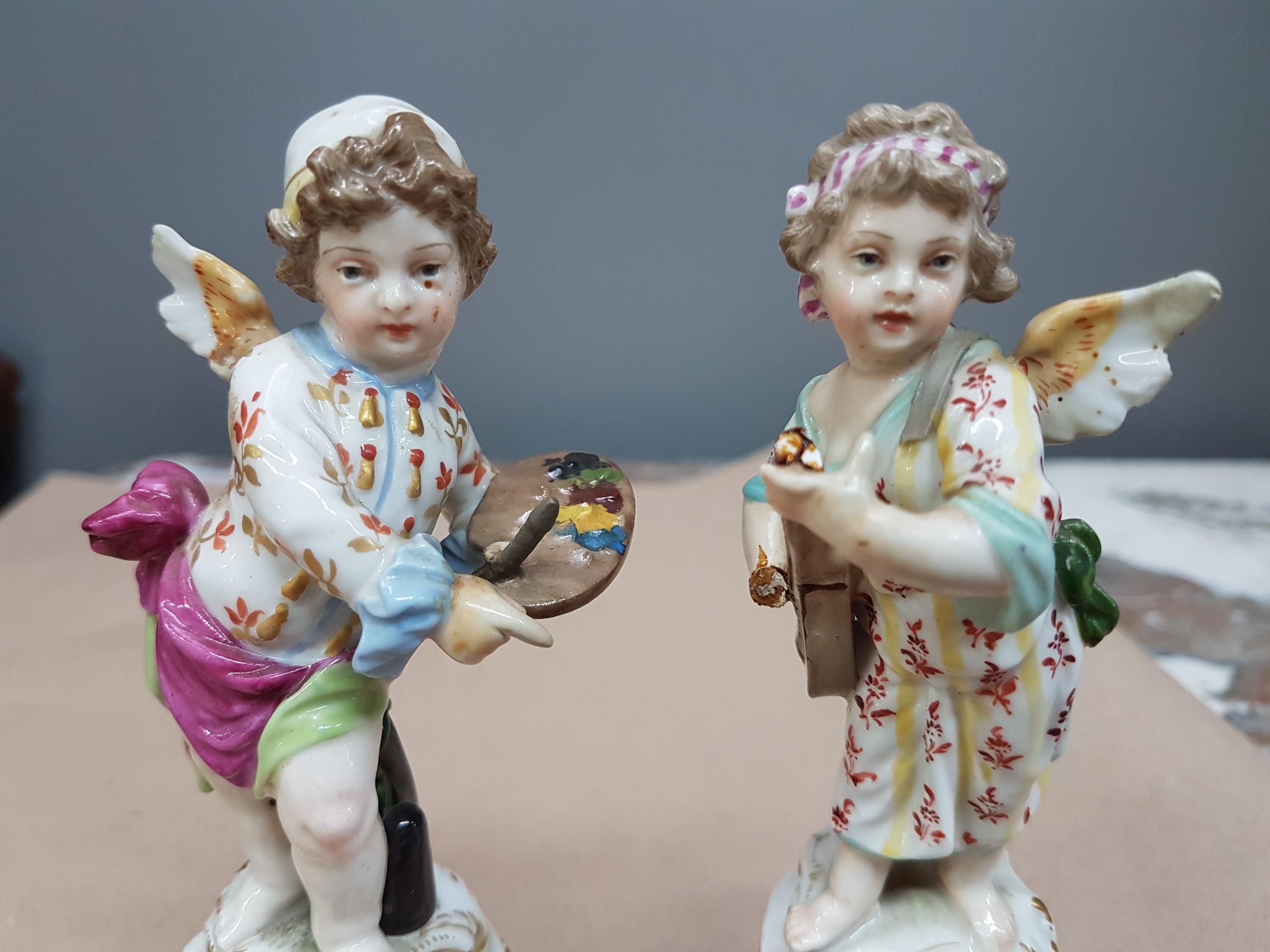 Detail e: Paar Porzellanfiguren, KPM Berlin, um 1900, verkleidete Amoretten Musikant und Maler, beide rest., Musikant vom Sockel gelöst und bestoßen, bunt ...
