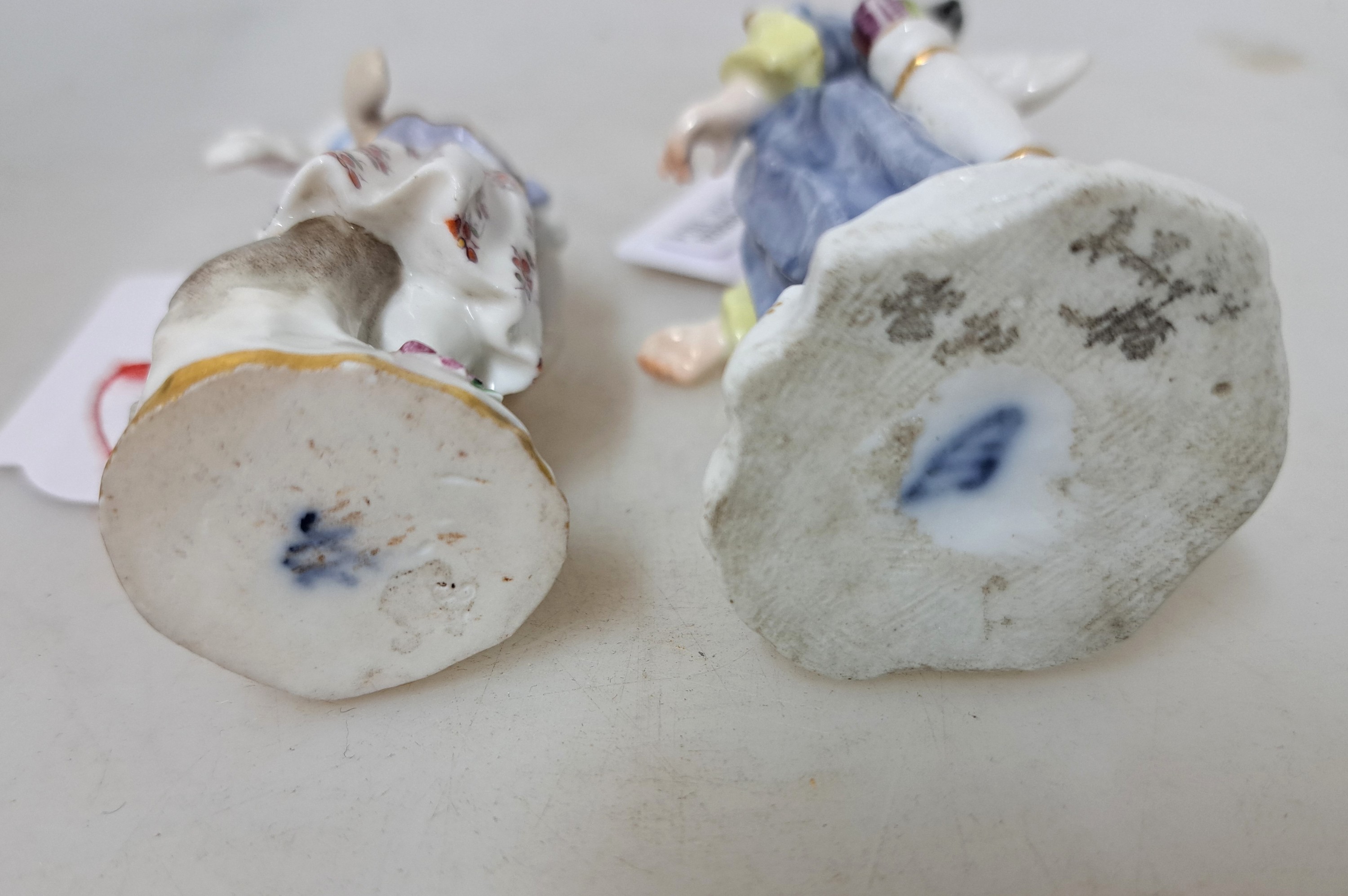 Detail b: 2 Amoretten, um 1850-1924, a. Meissen: verkleidete Amorette, polychrom bemalt, Goldstaffage, l. besch. bzw. rest., H. ca. 8.5 cm, b. ...