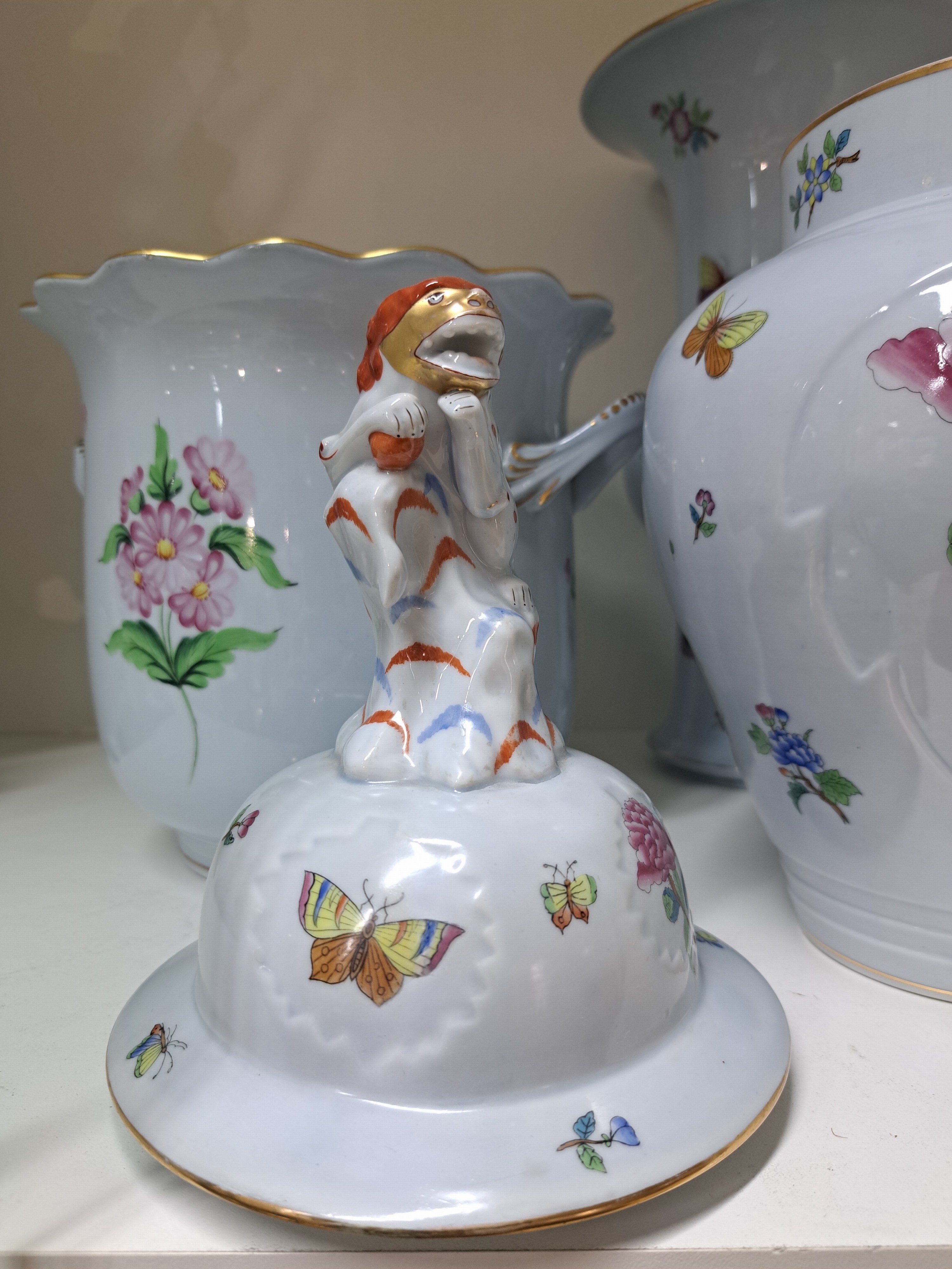 Detail b: Zwei Vasen und ein Übertopf, Herend, Porzellan, blaugrundig, bemalt, 1. Deckelvase, ind. Blumen mit Schmetterling, H. ca. 40 cm, 2. Ku-Vase, H: 33.5 ...