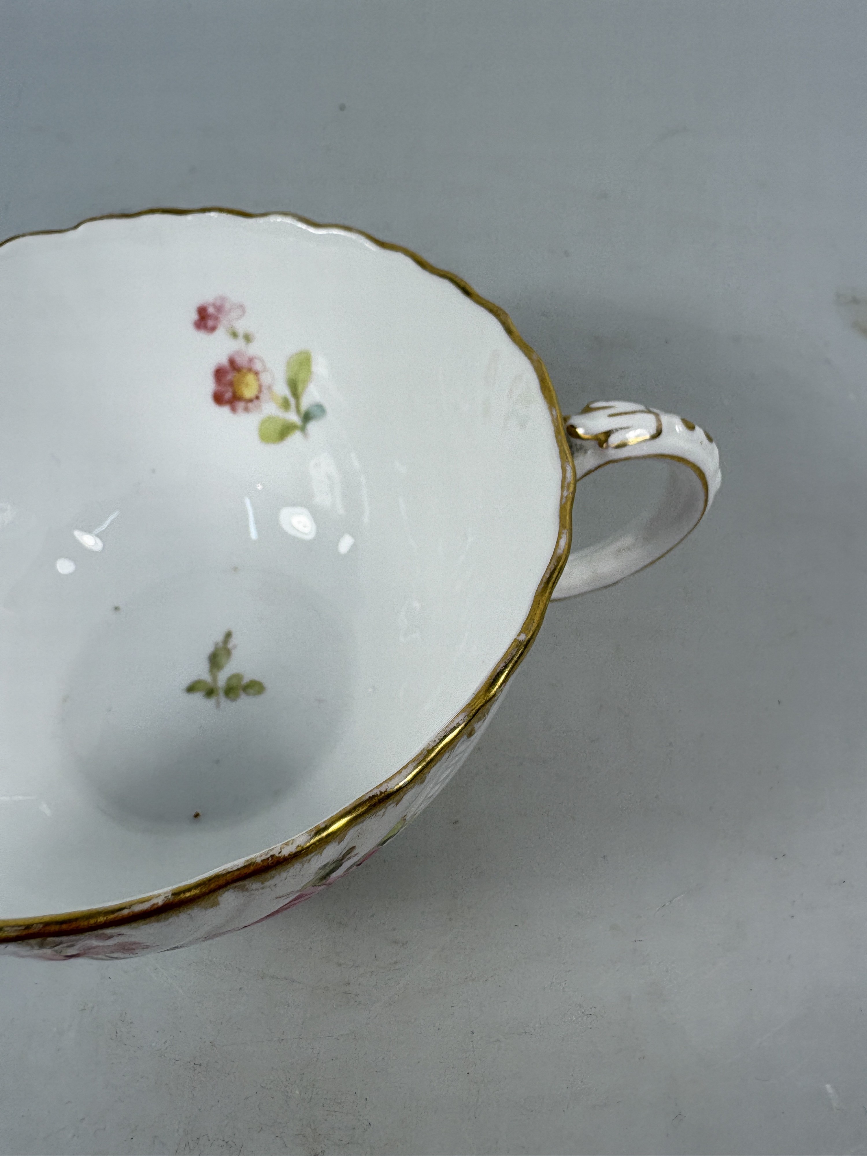 Detail k: 3 Tassen mit Untertassen, Sarreguemines und ein Gefäß Herend, 20. Jh., Tassen mit Untertassen, Goldstaffage, H.ca. 5.5 cm, eine Untertasse rest., ...