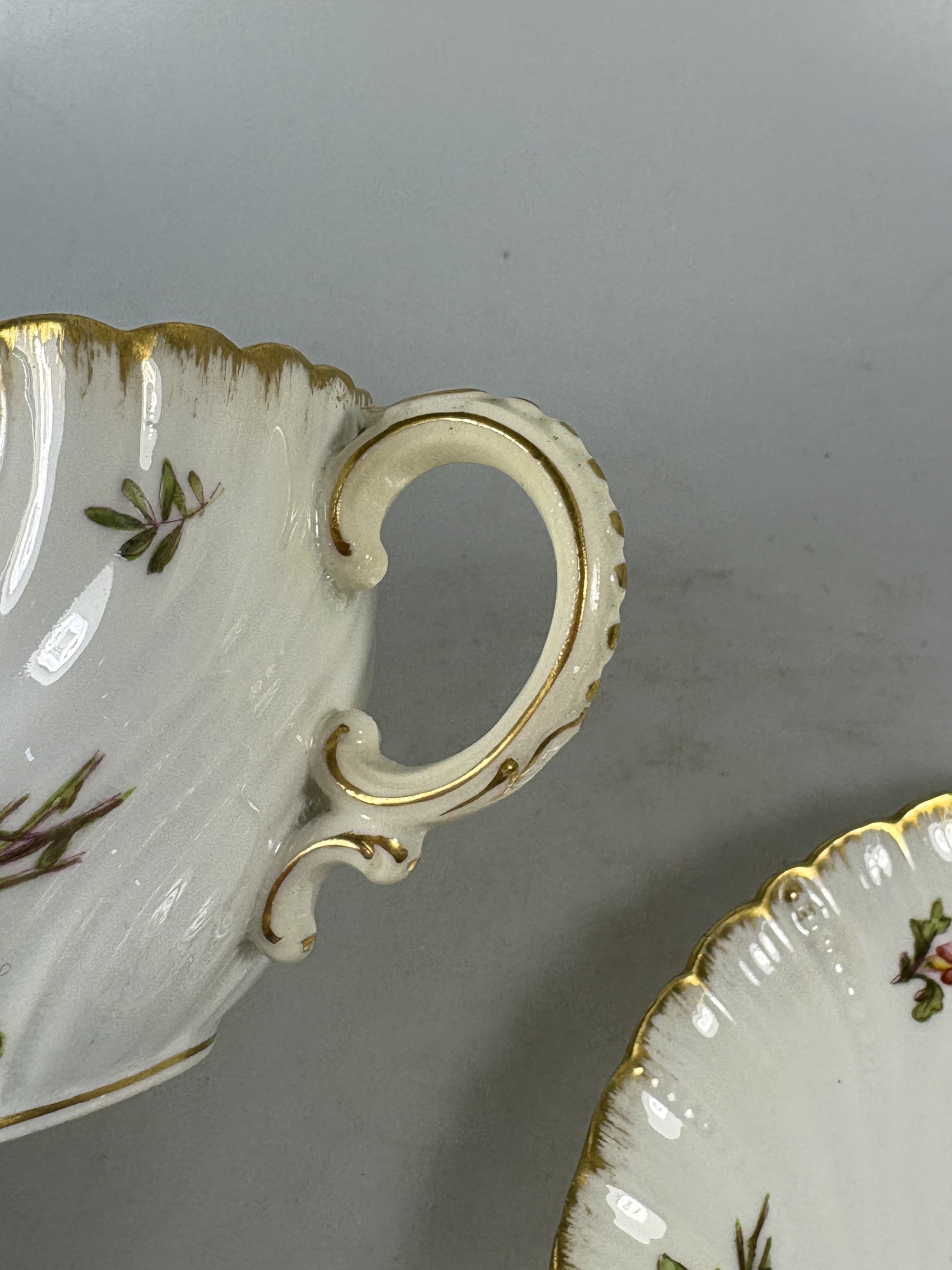 Detail q: 3 Tassen mit Untertassen, Sarreguemines und ein Gefäß Herend, 20. Jh., Tassen mit Untertassen, Goldstaffage, H.ca. 5.5 cm, eine Untertasse rest., ...