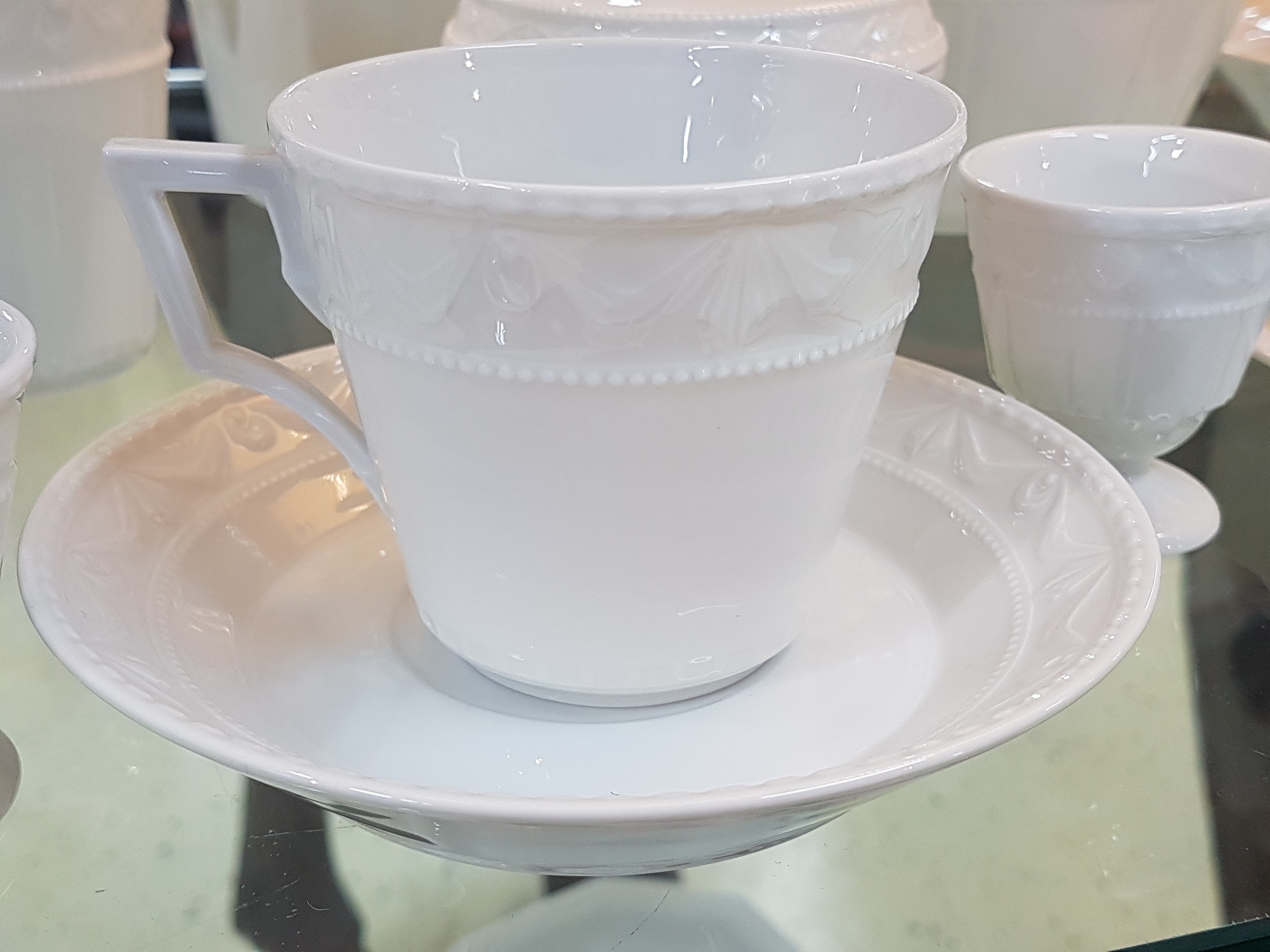 Detail d: Frühstücksservice Kurland, KPM Berlin, 20. Jh., Weißporzellan, Reliefzier, 12 Tassen mit UT, 12 Teller D. 19,5 cm, 6 Eierbecher, Sahnegießer und ...