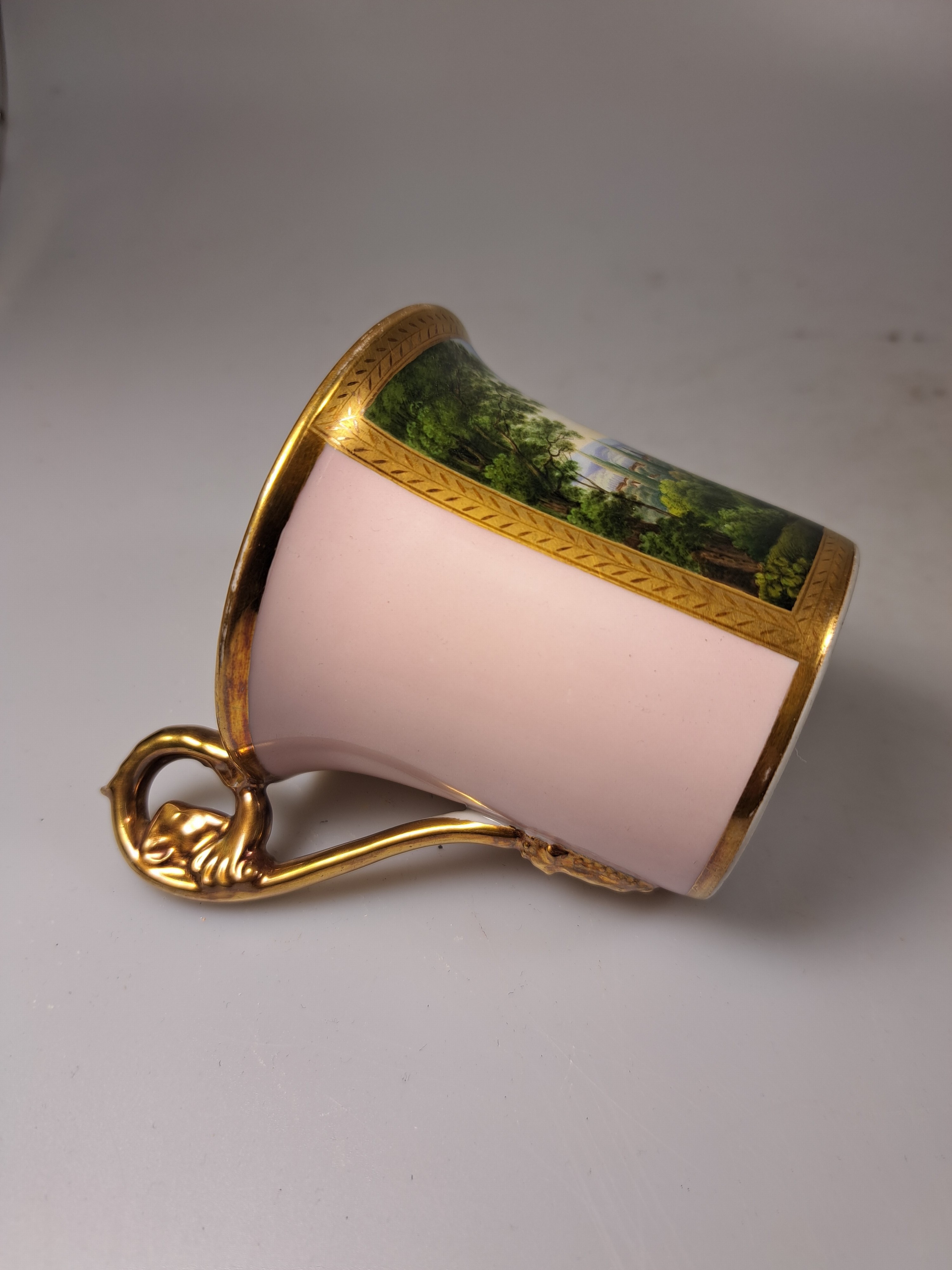 Detail c: Tasse mit Untertasse, deutsch, KPM Berlin, Mitte 19. Jh., Porzellan, altrosa Fond, in goldgerahmter Kartusche feine polychrome Landschaftsmalerei, ...