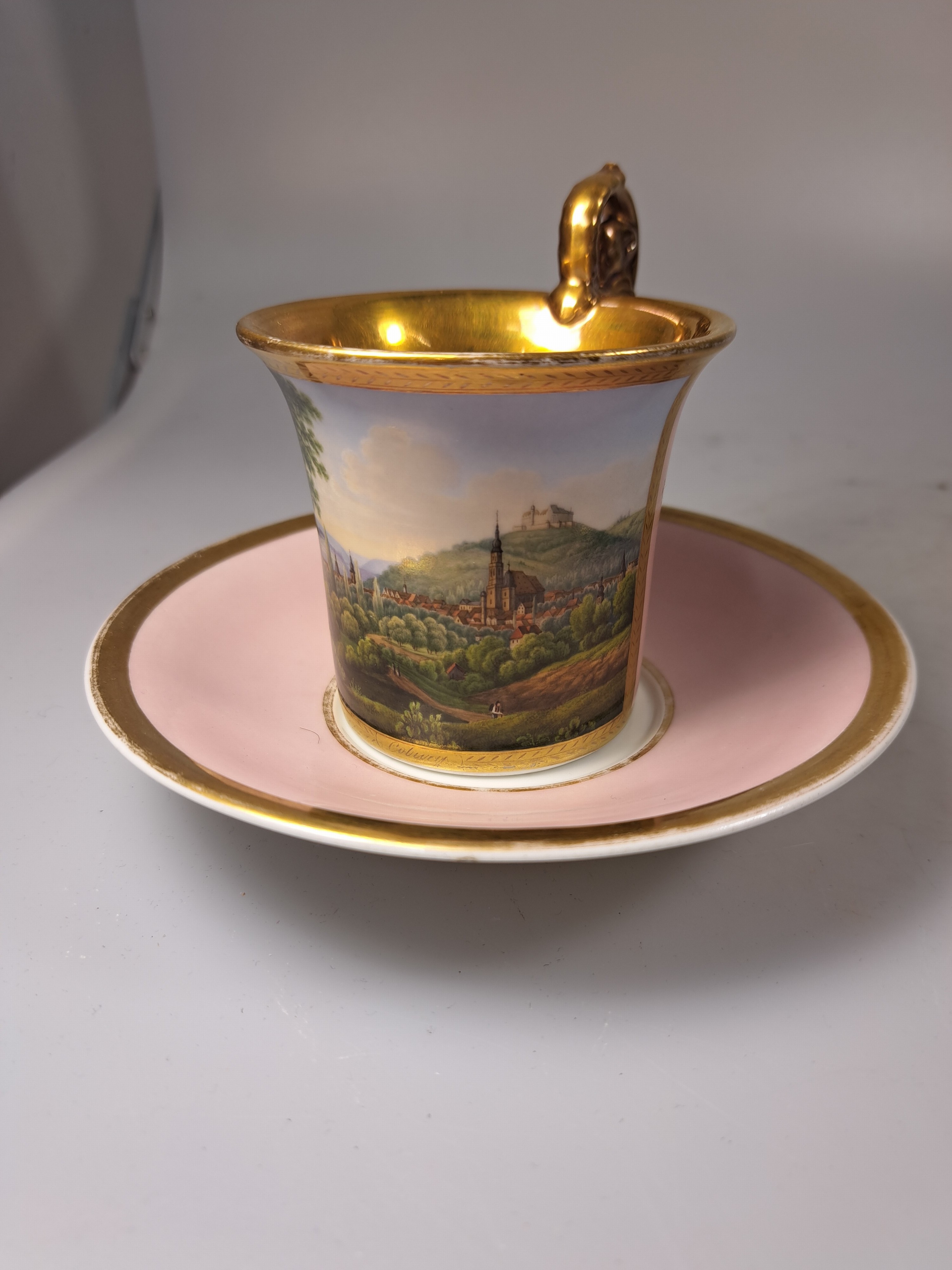 Detail d: Tasse mit Untertasse, deutsch, KPM Berlin, Mitte 19. Jh., Porzellan, altrosa Fond, in goldgerahmter Kartusche feine polychrome Landschaftsmalerei, ...