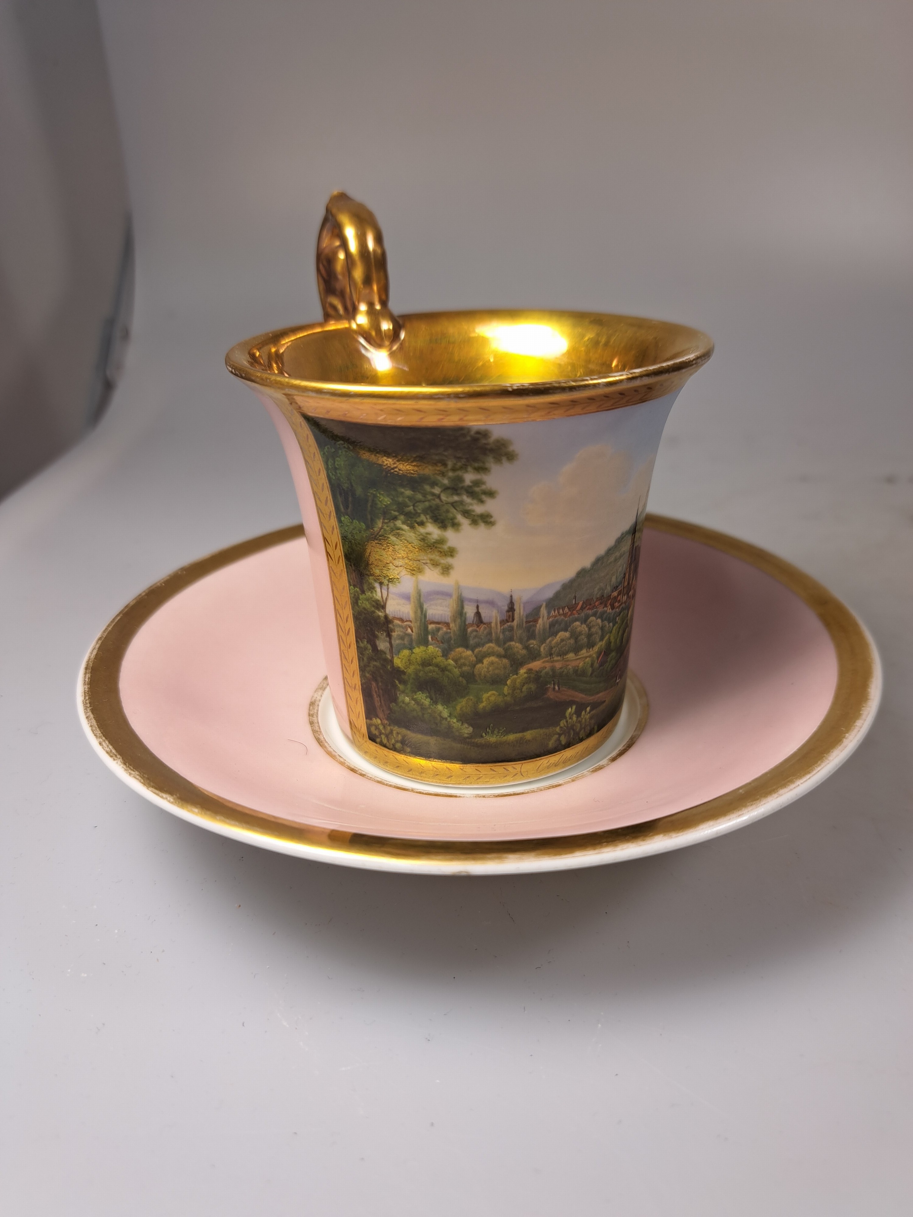 Detail e: Tasse mit Untertasse, deutsch, KPM Berlin, Mitte 19. Jh., Porzellan, altrosa Fond, in goldgerahmter Kartusche feine polychrome Landschaftsmalerei, ...