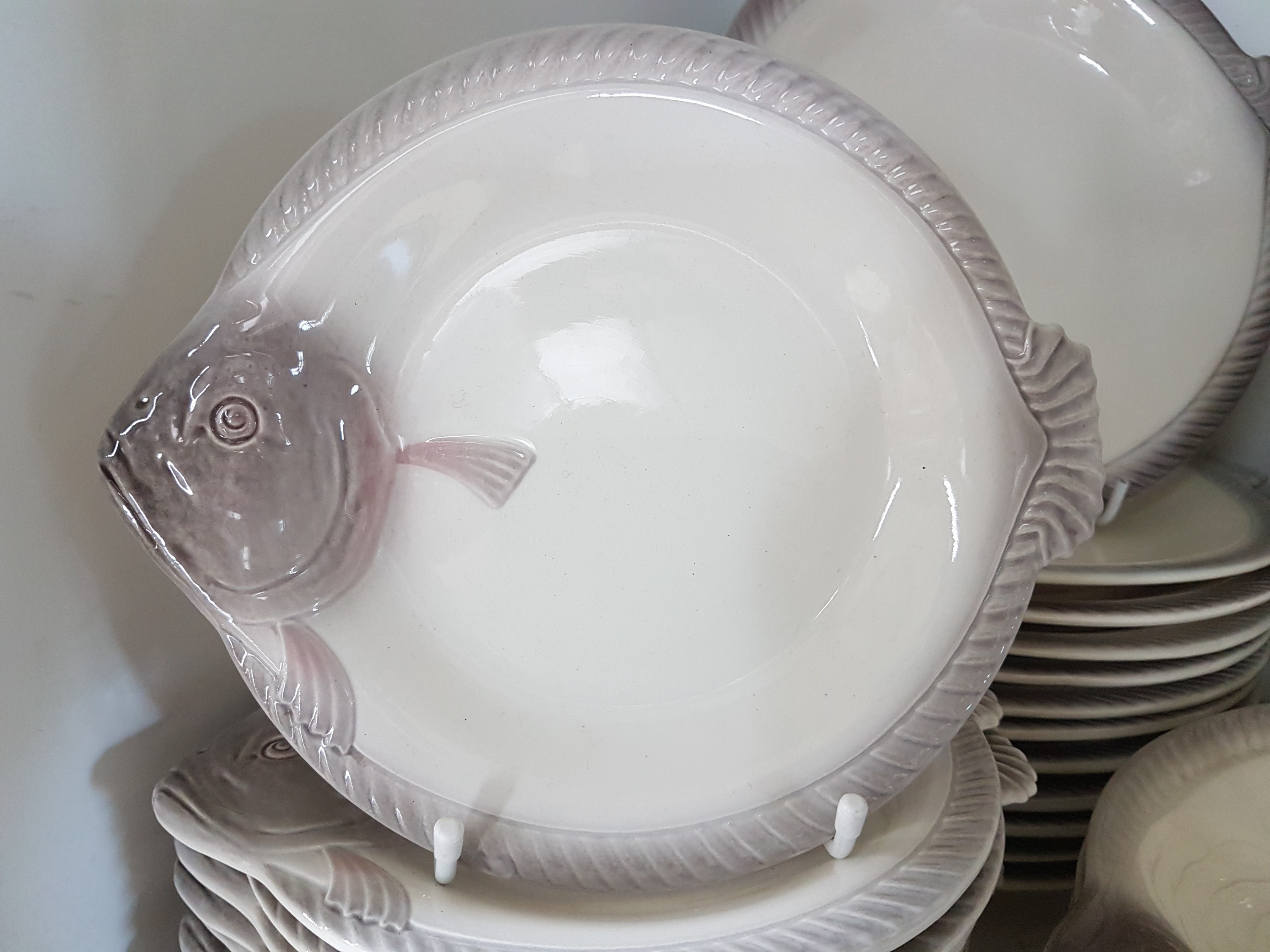 Detail c: Fisch- und Austernservice, Wächtersbach, 1920er/1930er Jahre, Feinsteingut, in Form von Fischen, 12 flache Teller, eine Platte, 12 kleine Teller, 12 ...