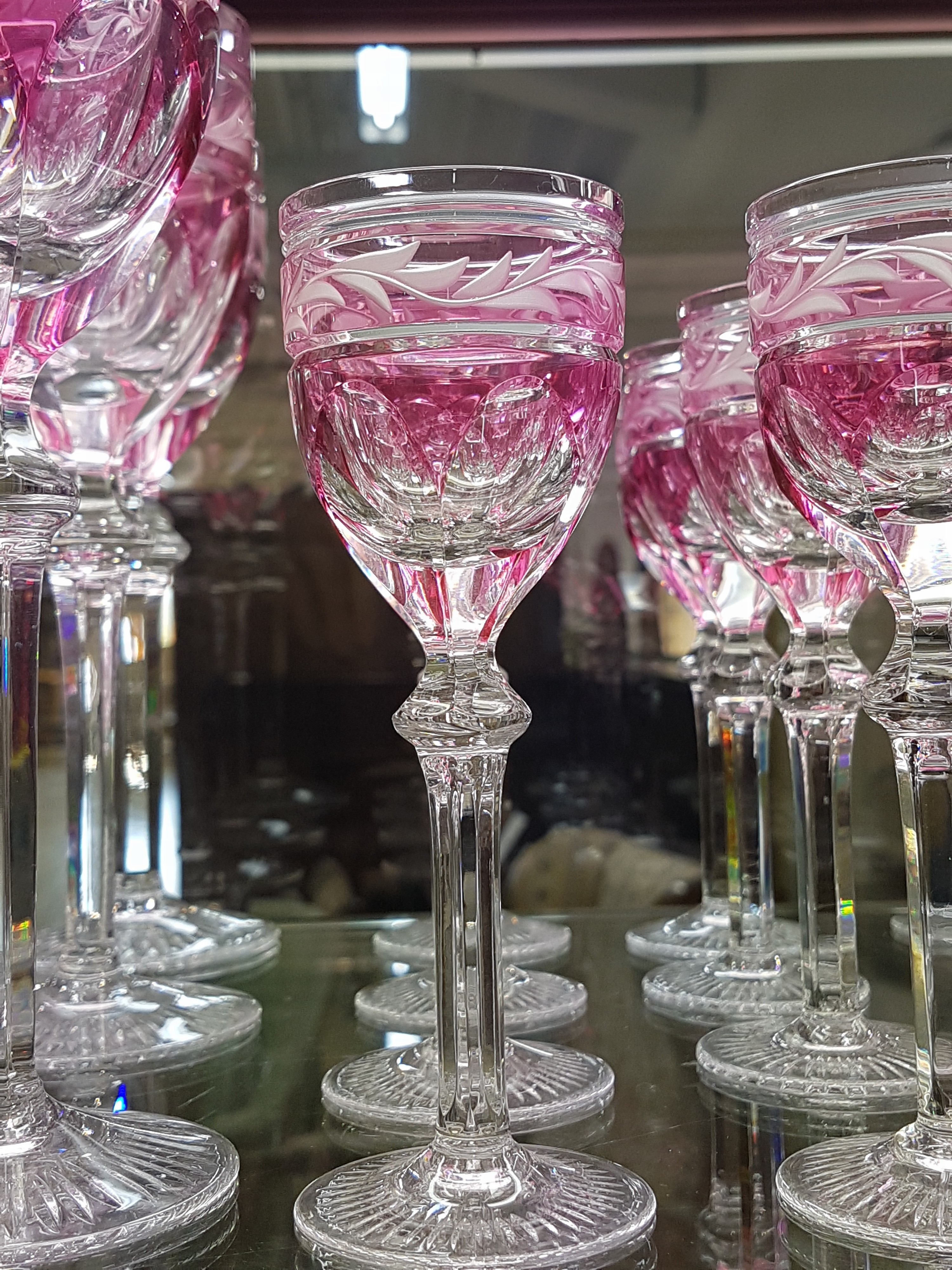 Detail c: 12 Wein- und 12 Likörgläser, wohl Val St. Lambert, 1920er Jahre, Kristallglas partiell rosa überfangen, geschnitten und geschliffen, H. ca. 22 ...