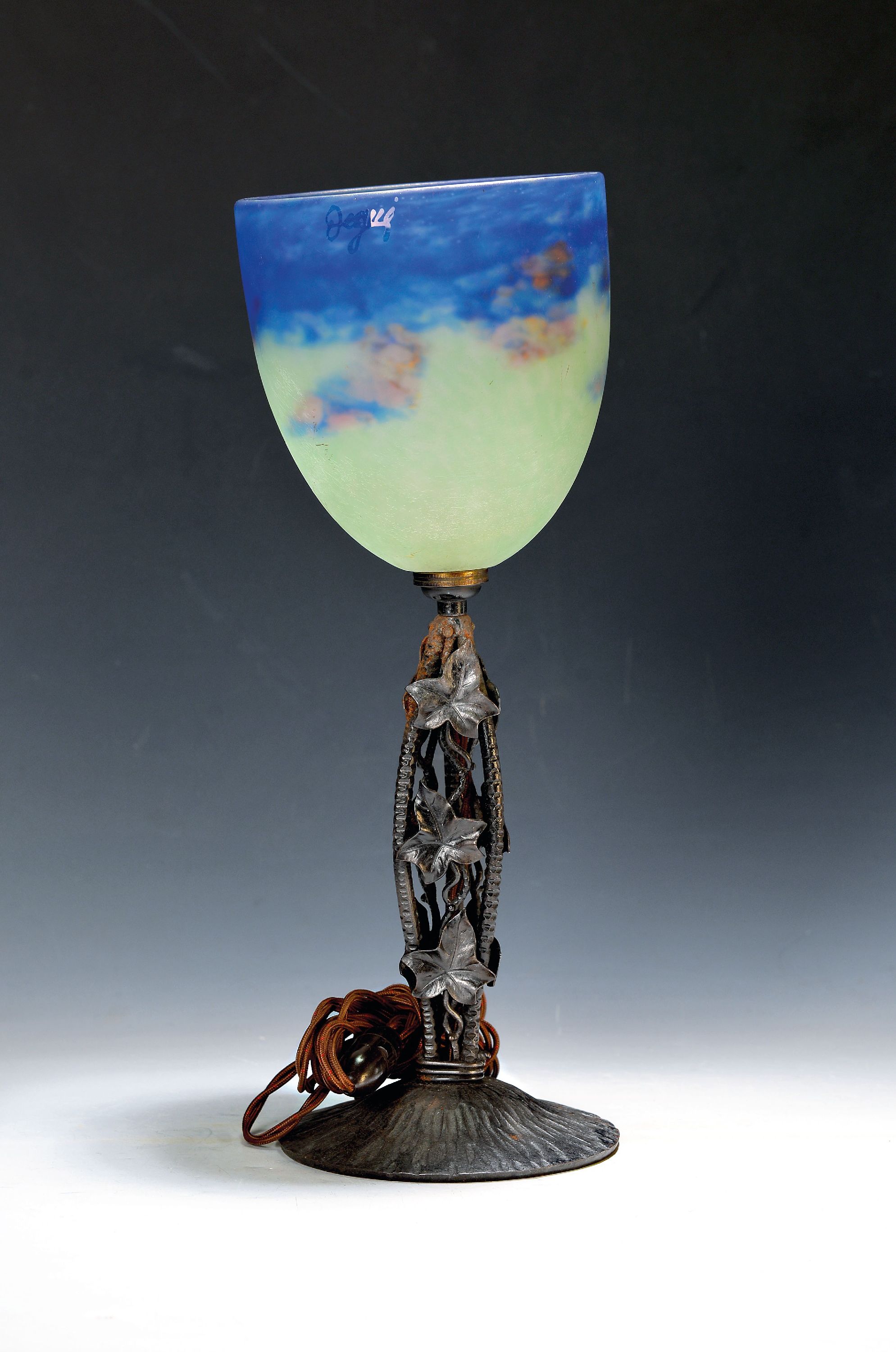 Tischlampe, sign. Degué, um 1920-30, Eisenfuß mit Efeublattdekor, Schirm sign., mit grünen, blauen und orangefarbenen Einpuderungen, nach oben ...