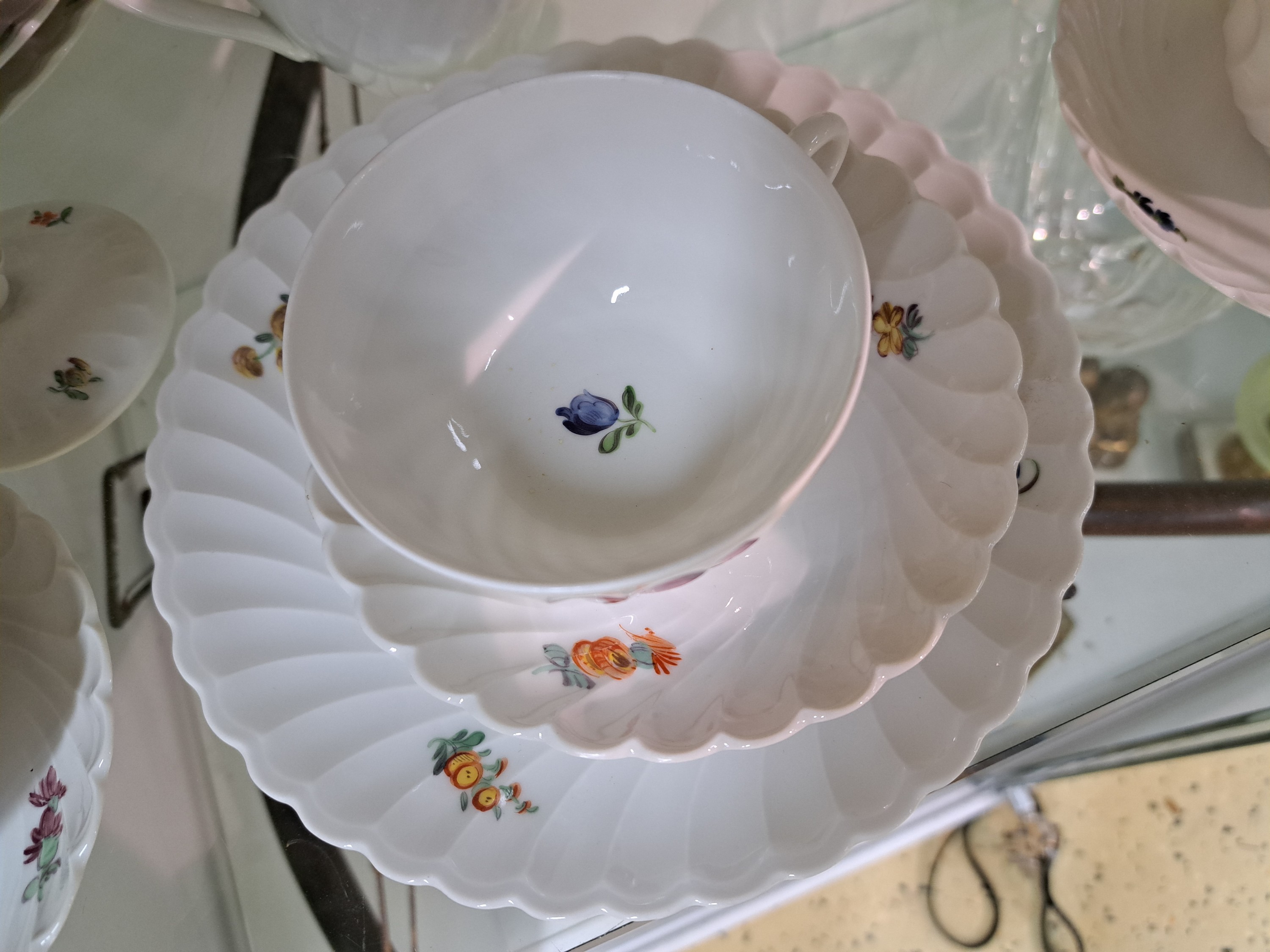 Detail d: Kaffeeservice, Nymphenburg, 20. Jh., dünnwandiges Porzellan, Fächerrelief, bunte Blumenmalerei, 12 Kuchenteller, 12 Tassen mit 12 Untertassen, ...