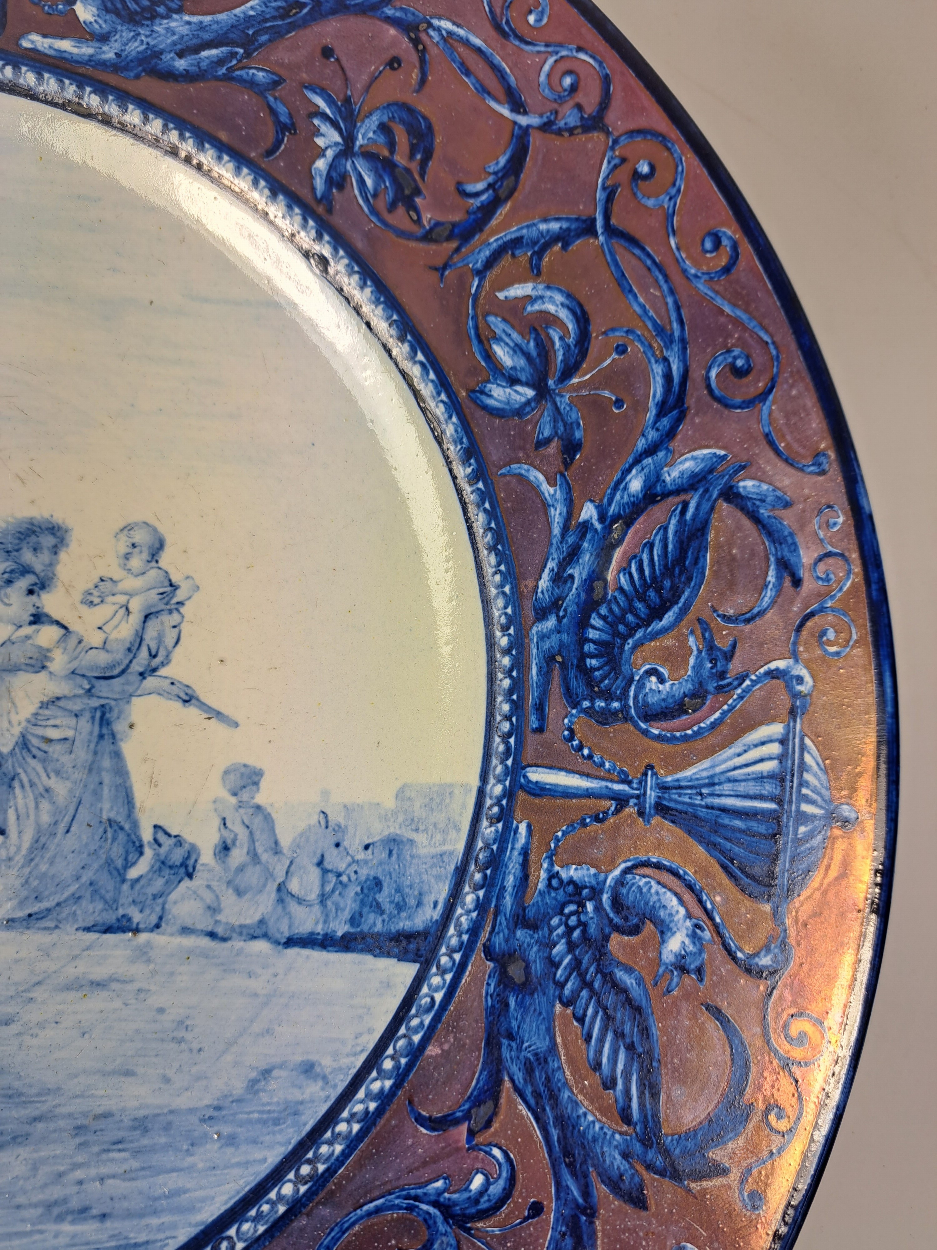 Detail l: Fayenceteller, Italien, 19. Jh., mit umlaufenden Renaissancedekor staffiert, lüstriert, im Spiegel feine figürliche Handbemalung, D. ca. 37 cm