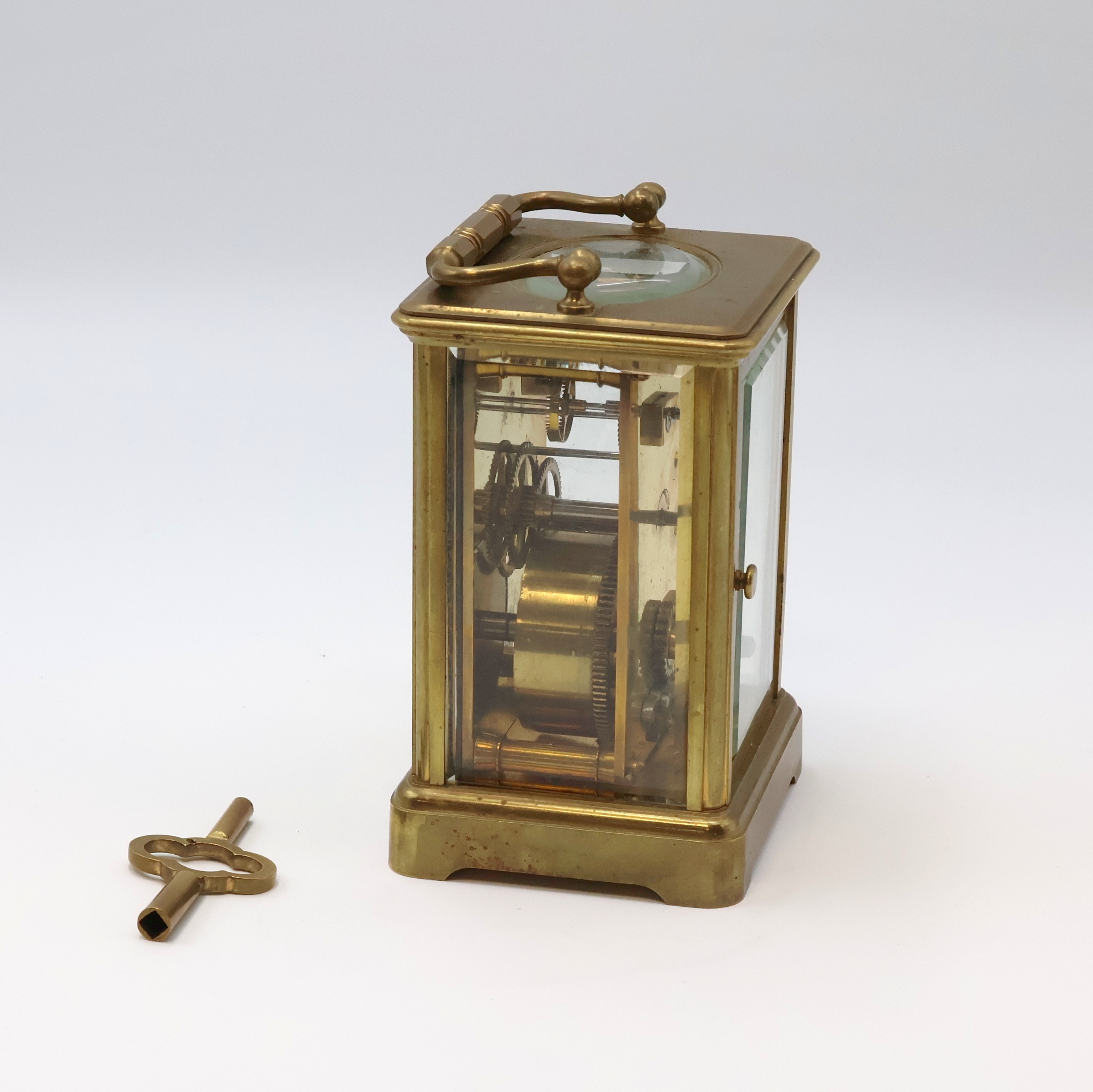 Detail d: Französische 8-Tage Reiseuhr in 5-seitig verglastem Messinggehäuse, um 1900, schlichtes Geh. m. Tragebügel, facett-vergl., rücks. zu öffnen f. ...