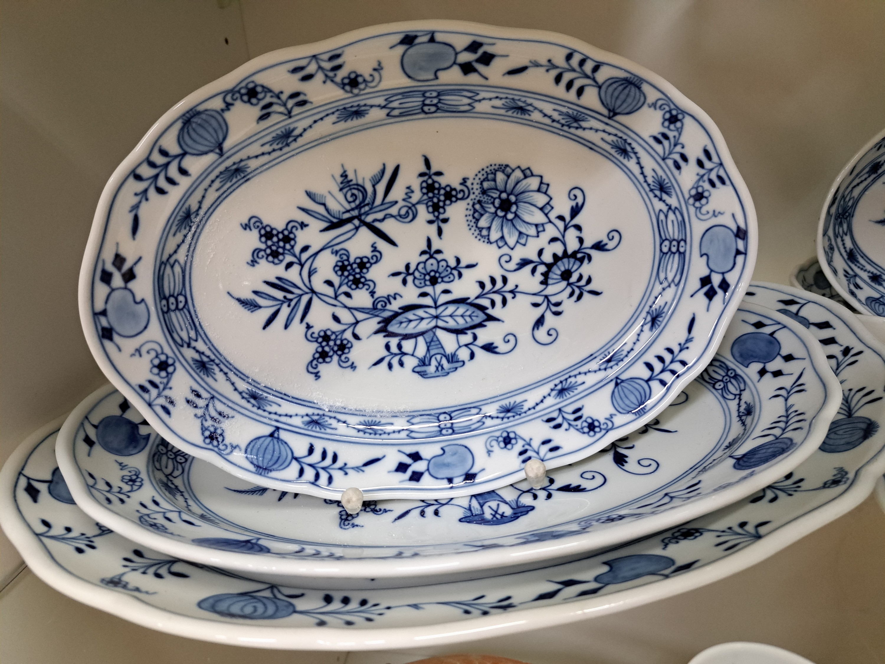 Detail q: Speiseservice, Meissen, 20. Jh., Zwiebelmuster, 8 Menueteller, 6 Suppenteller, 12 Brotteller, drei ovale Platten, Sauciere, drei runde Platten, zwei ...