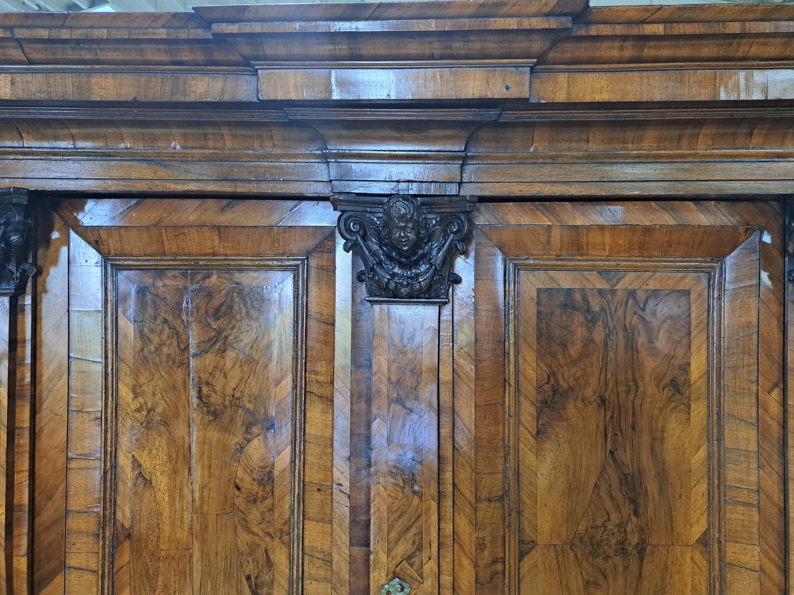Detail a: Barock-Schrank/Pilasterschrank, Braunschweig, um 1720/30, Nußbaumfurnier auf Eichekorpus, zweitürig, 2 Schubladen, weit ausladendes Gesims, ...