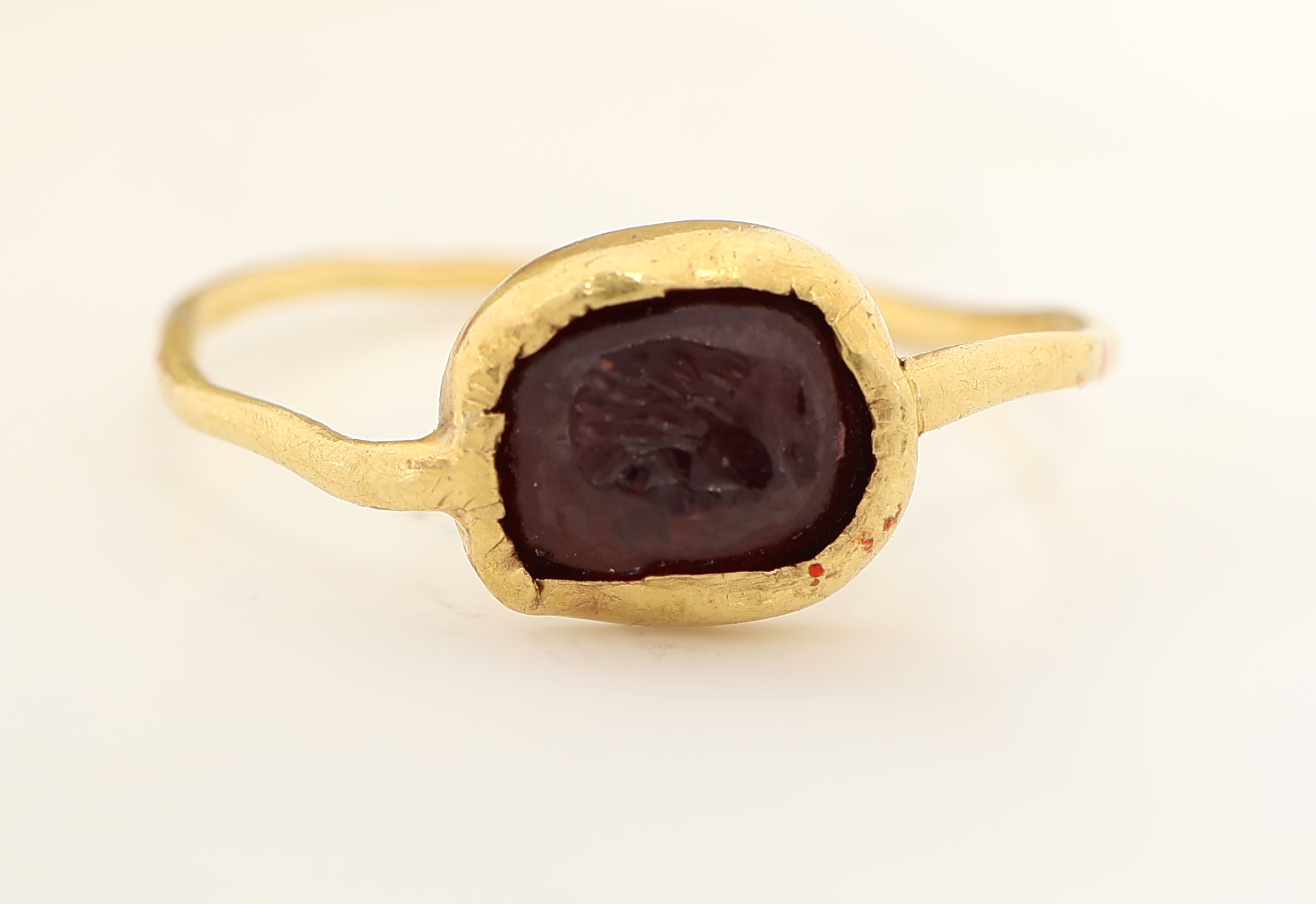 Detail c: 18 kt Gold Granat-Ring, mind. GG 750/000 gepr., Granat mit Intaglio, Darstellung eines Herrenkopfes, RW 49.5, unförmige Ringschiene, Wachsabdruck ...