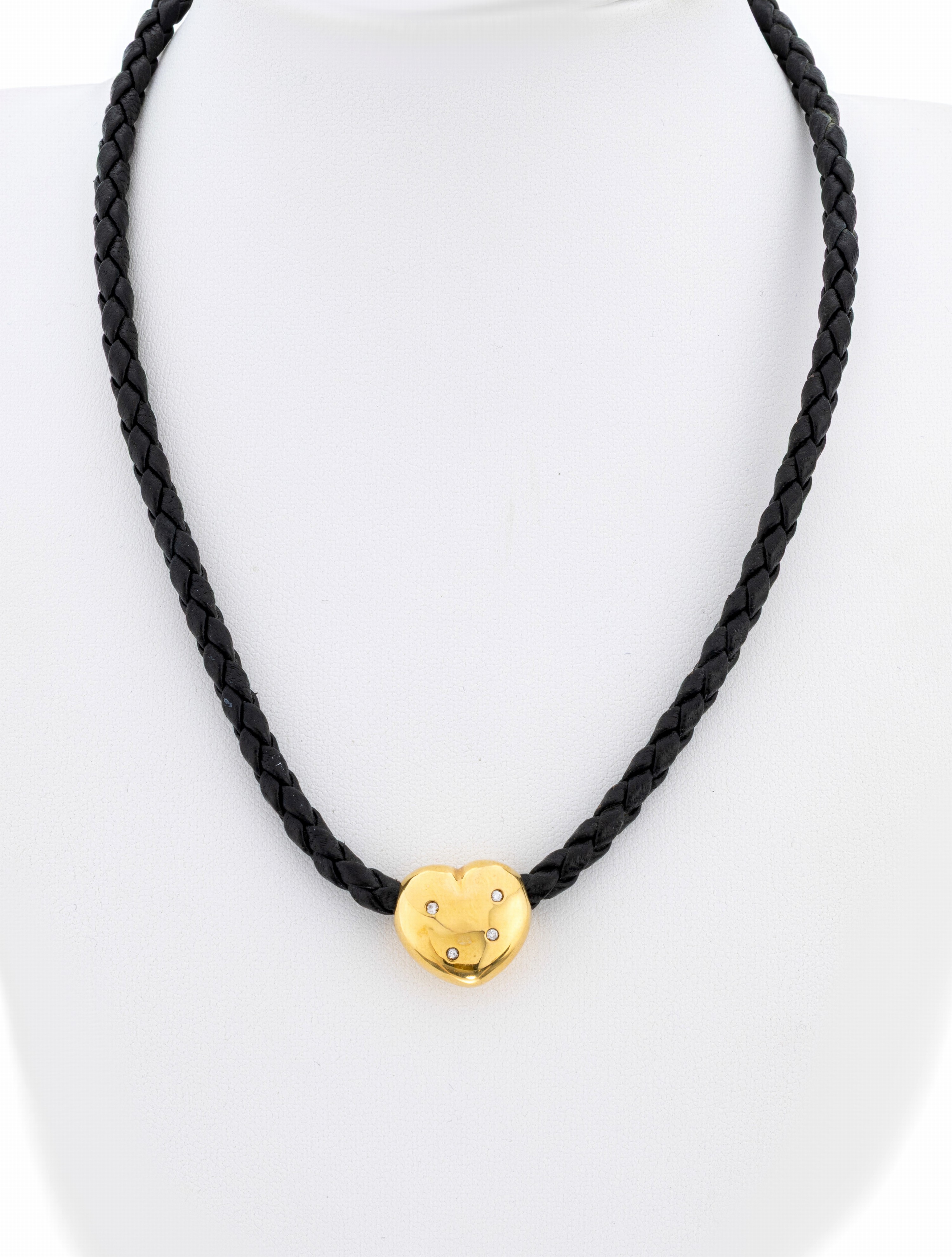 18 kt Gold Brillant-Herzanhänger, GG 750/000, 4 Brillanten zus. ca. 0.04 ct Weiß/si, an schwarzem Ledercollier, geflochten, L. ca. 40 cm, ...