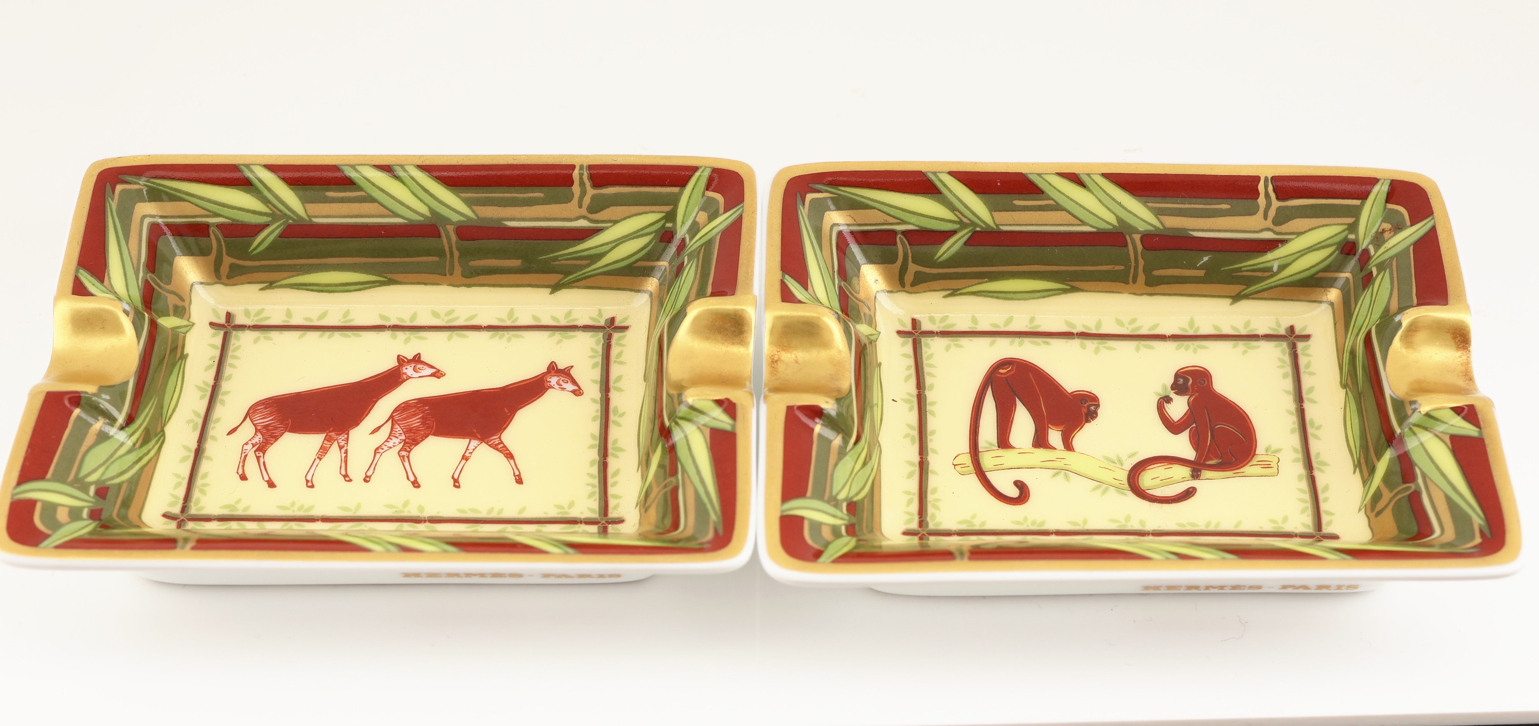 Detail a: Seltenes HERMES Miniatur Aschenbecher-Paar ausder Jungle-Serie, Porzellan, cremefarb. Fond mit Affen- bzw. Okapi-Motiv, brauner Randmit grünem ...