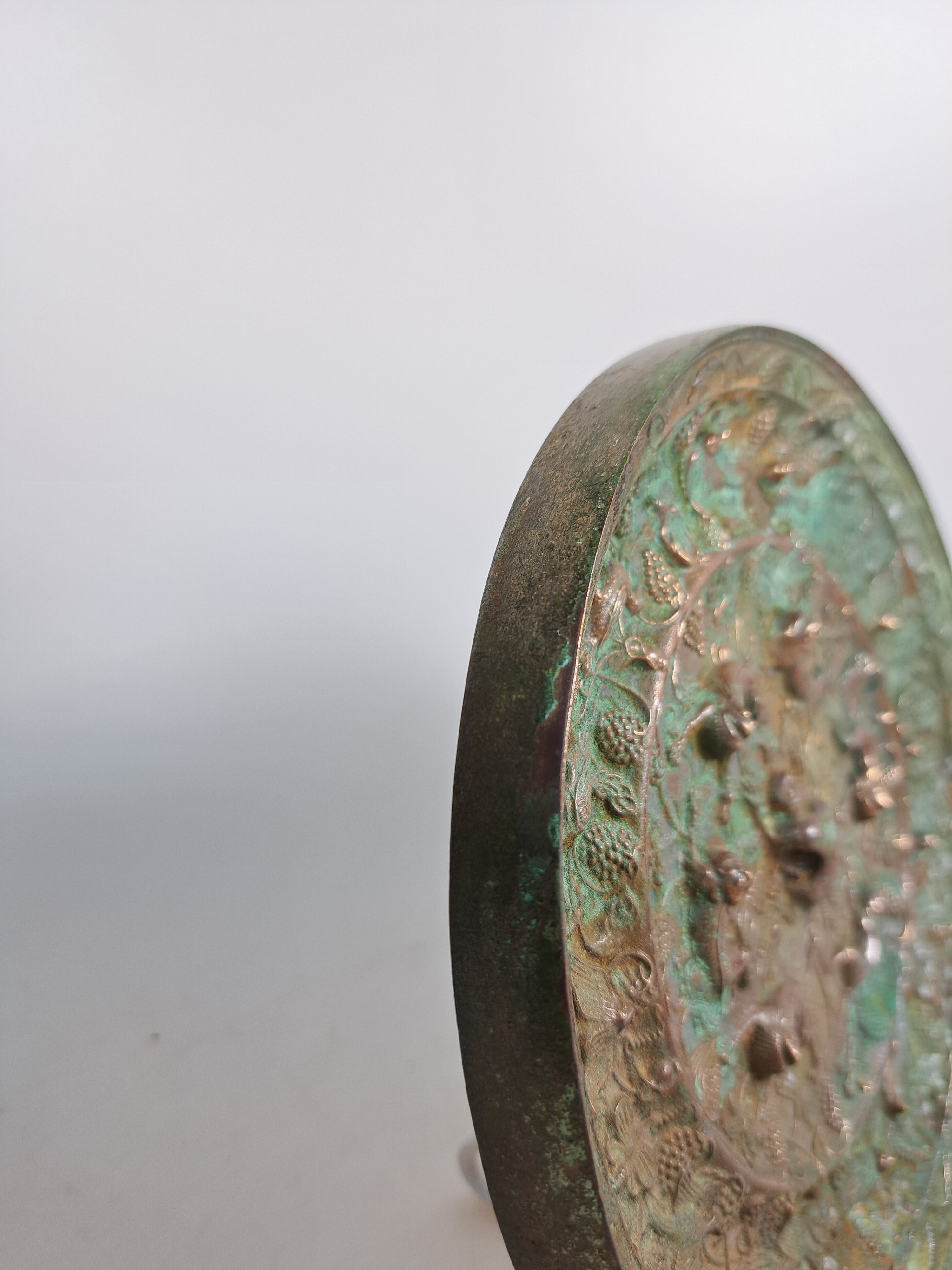 Detail d: Bronzespiegel, im Stil der Han-Dynastie, reliefiert mit Traubendekor und Tieren, D. ca. 19 cm