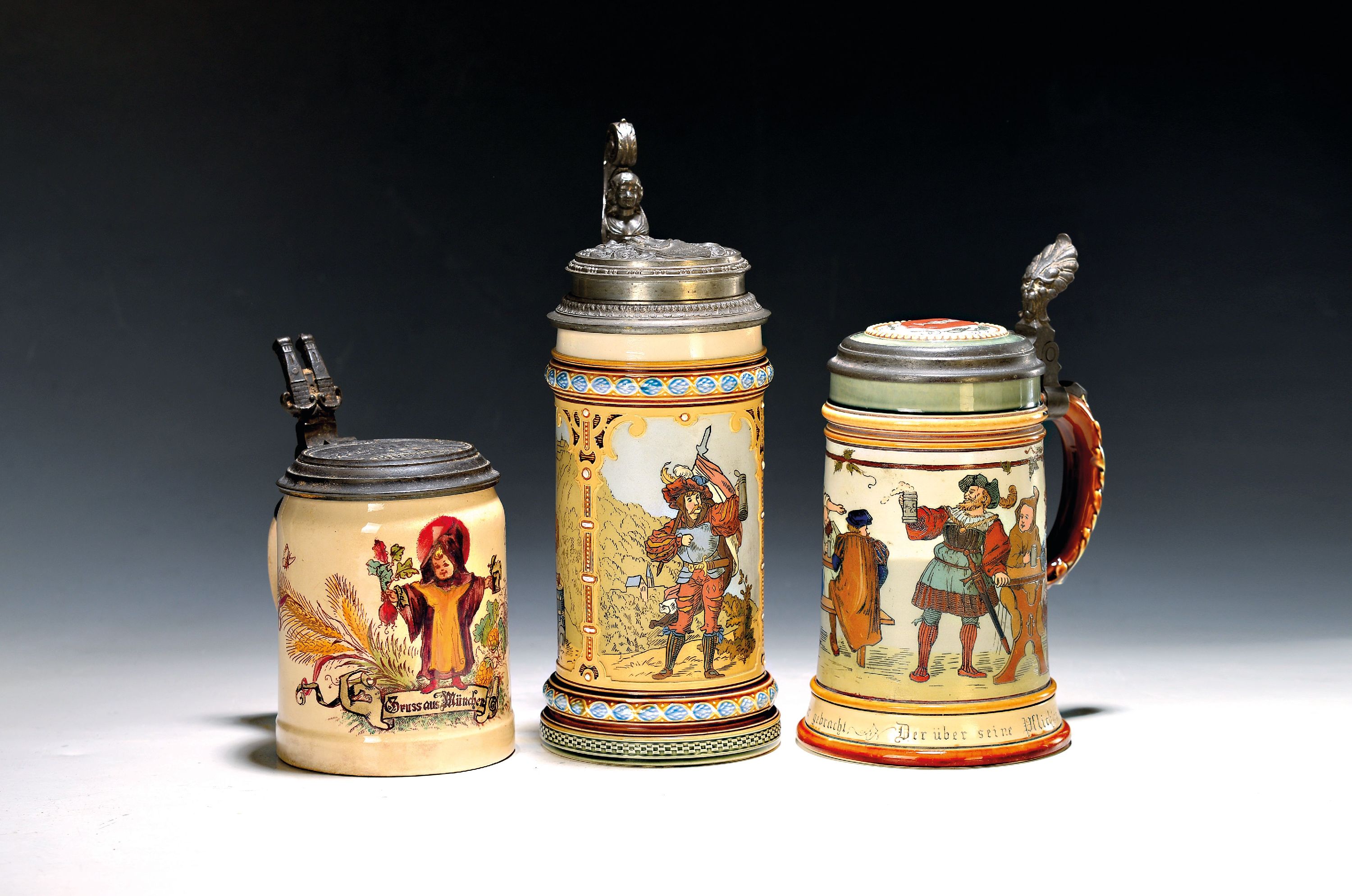 Drei Mettlach-Krüge, Villeroy & Boch, um 1900, Feinsteinzeug, a. 2003 mit Zinndeckel, geritzter Dekor, H. ca. 25.5 cm, Deckel bez. und dat. 1892; b. ...