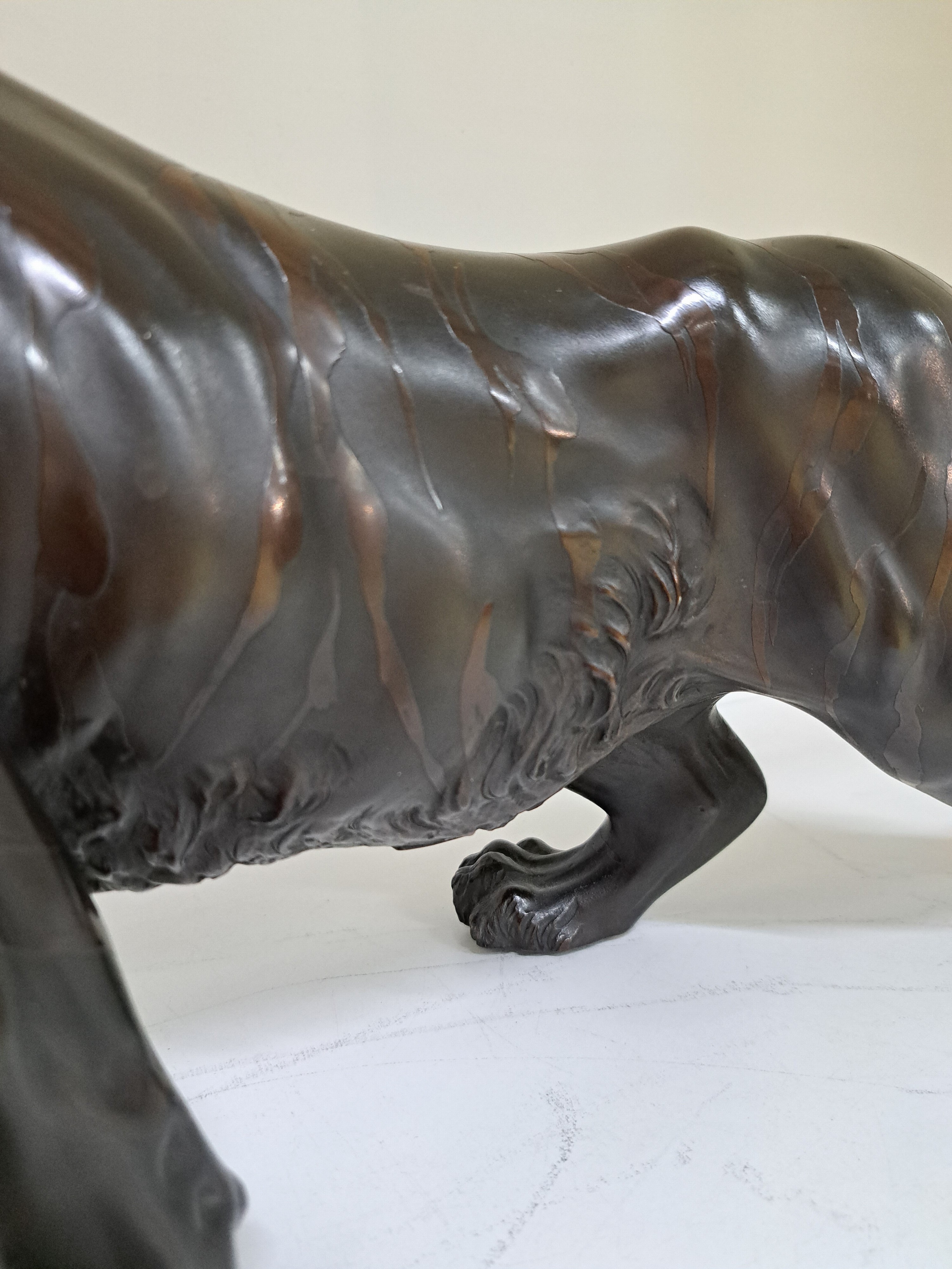 Detail e: Große Bronzefigur, China, 20. Jh., schreitender brüllender Tiger, am Boden Signet, H. ca. 28cm, L. ca. 71cm