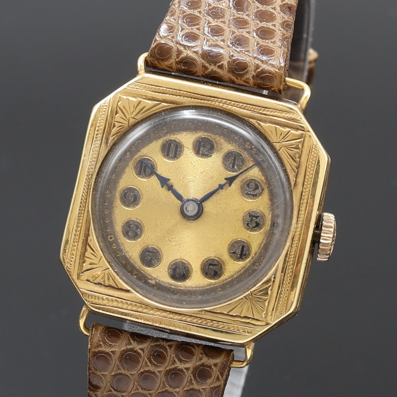 Detail a: Armbanduhr in GG 750/000 an Lederband, Schweiz um 1935, Handaufzug, 8-eckiges, grav. Scharniergeh., gold. Zifferbl. fl./pat., gebl. Zeiger, vern. ...