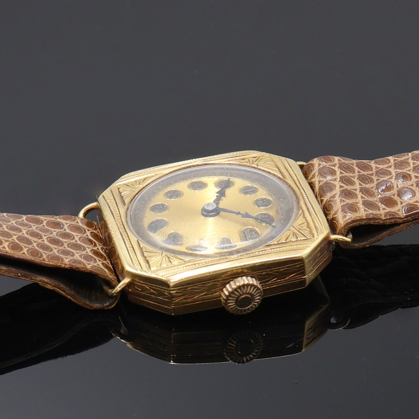 Detail b: Armbanduhr in GG 750/000 an Lederband, Schweiz um 1935, Handaufzug, 8-eckiges, grav. Scharniergeh., gold. Zifferbl. fl./pat., gebl. Zeiger, vern. ...