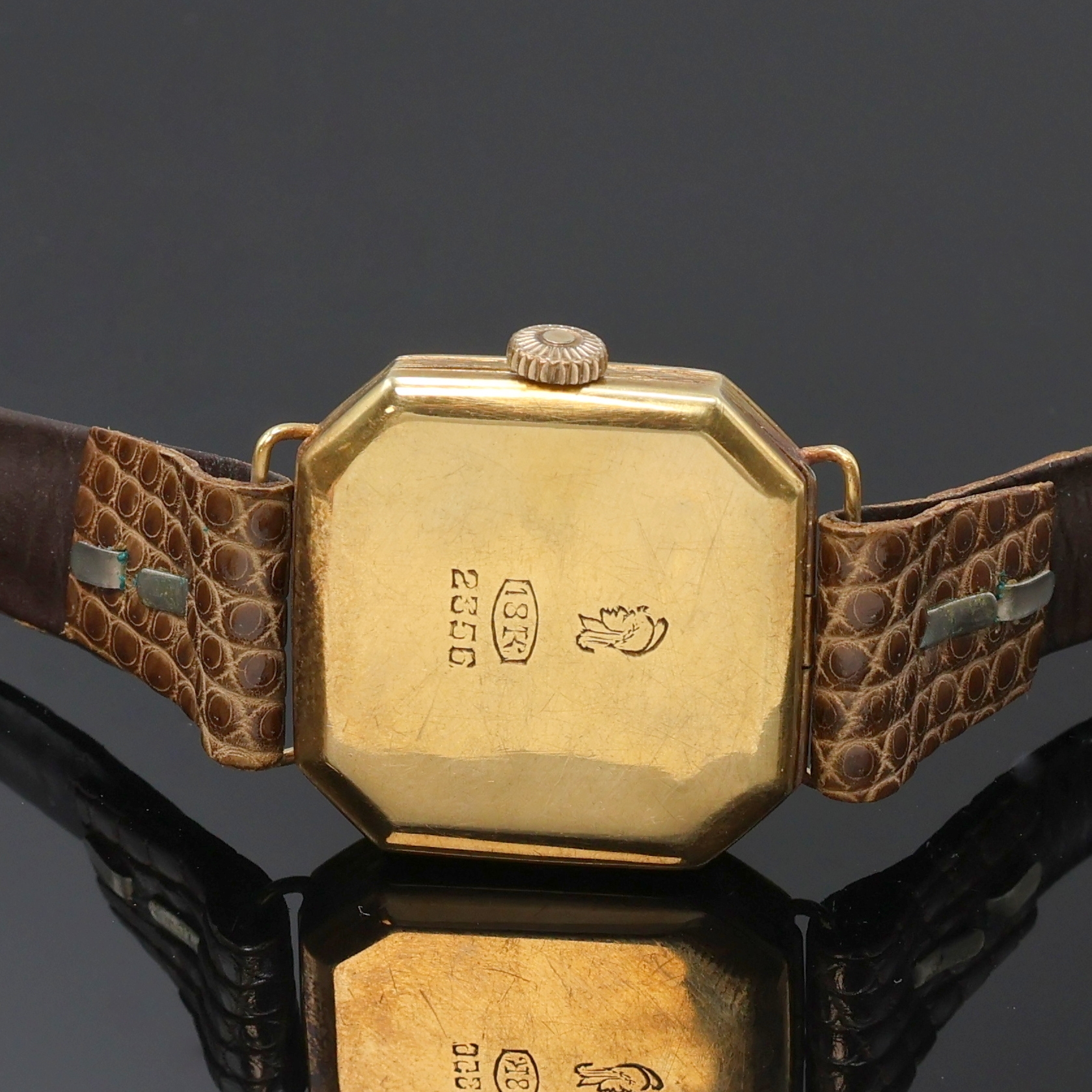 Detail c: Armbanduhr in GG 750/000 an Lederband, Schweiz um 1935, Handaufzug, 8-eckiges, grav. Scharniergeh., gold. Zifferbl. fl./pat., gebl. Zeiger, vern. ...