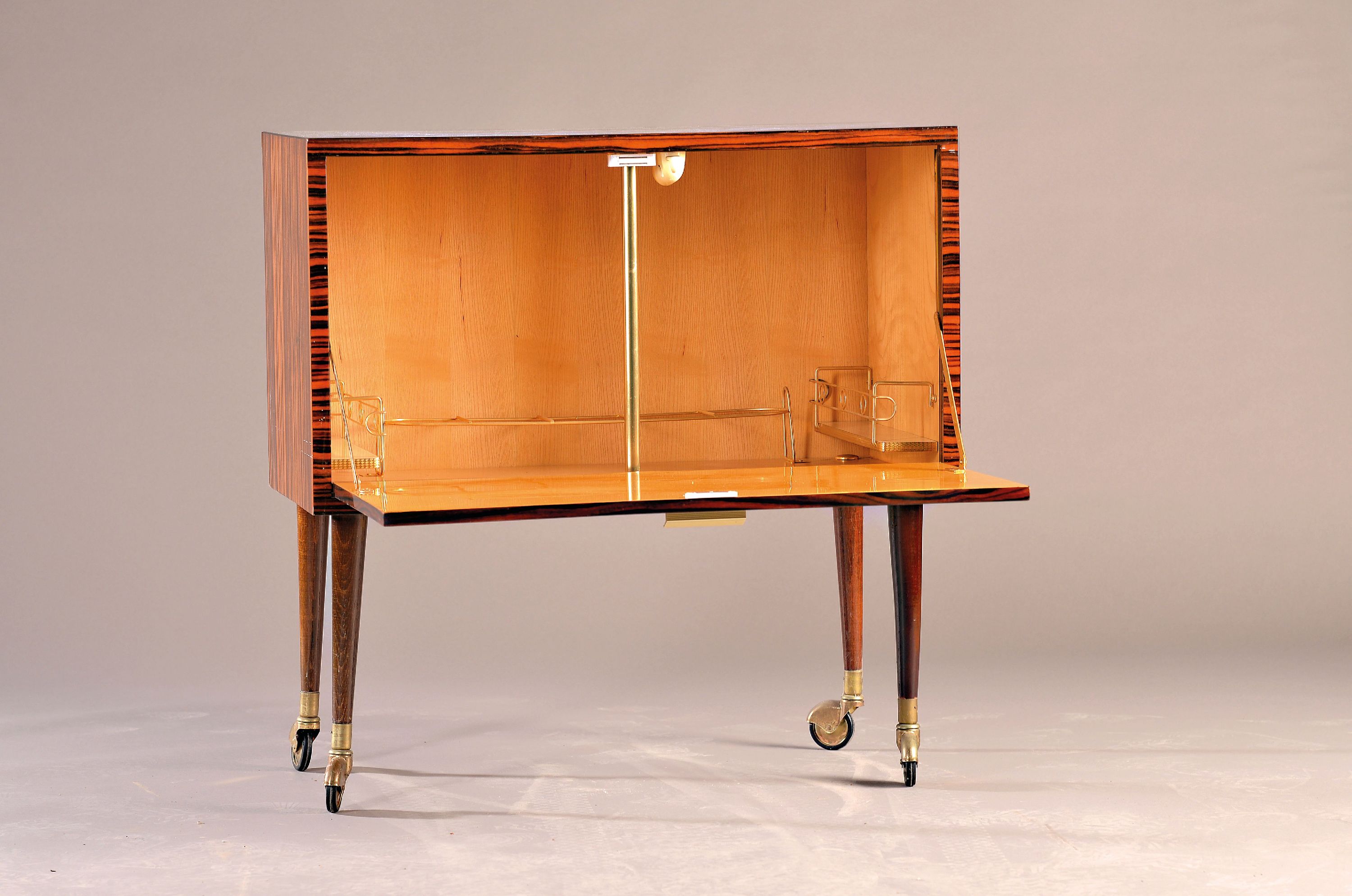 Detail a: Barschrank, deutsch, 1960er-Jahre, Makassar -Furnier, Front mit einer Klappe, sparsame Inneneinrichtung mit Messingmonturen, auf vier konischen ...