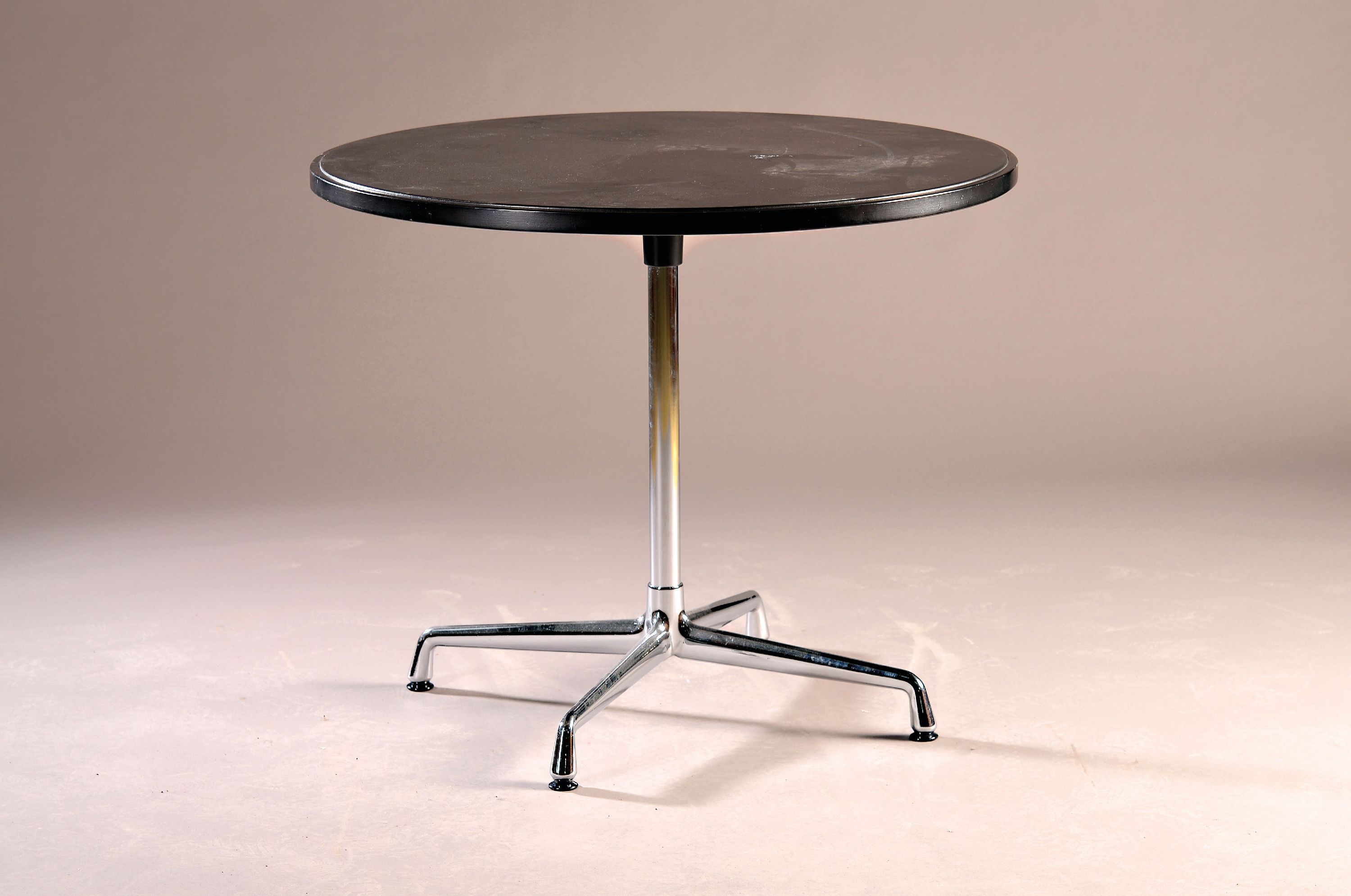Detail a: Runder Tisch, Entwurf Charles Eames, Ed. Vitra, Oberfläche mit schwarzem, Untergestell Metall verchromt, H. ca. 75 cm, D. ca. 90 cm Gebrauchsspuren, ...