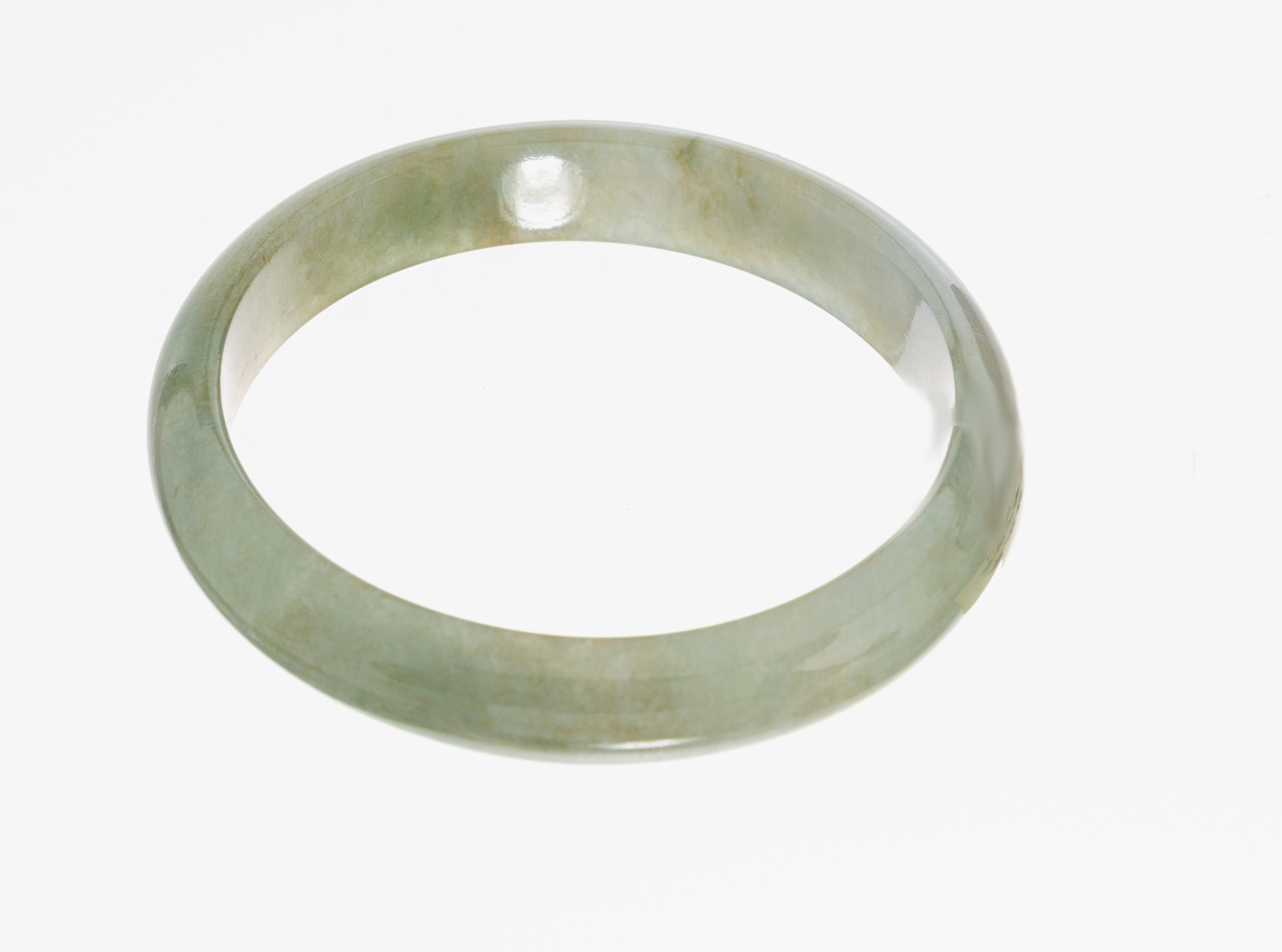 Detail a: Jade-Armreif, aus einem Stück geschnittenerArmreif, D. ca. 5.8 cm, B. ca. 12.2 mm, ca. 41.3 g, Zertifikat auf chinesisch anbei, neuwertig