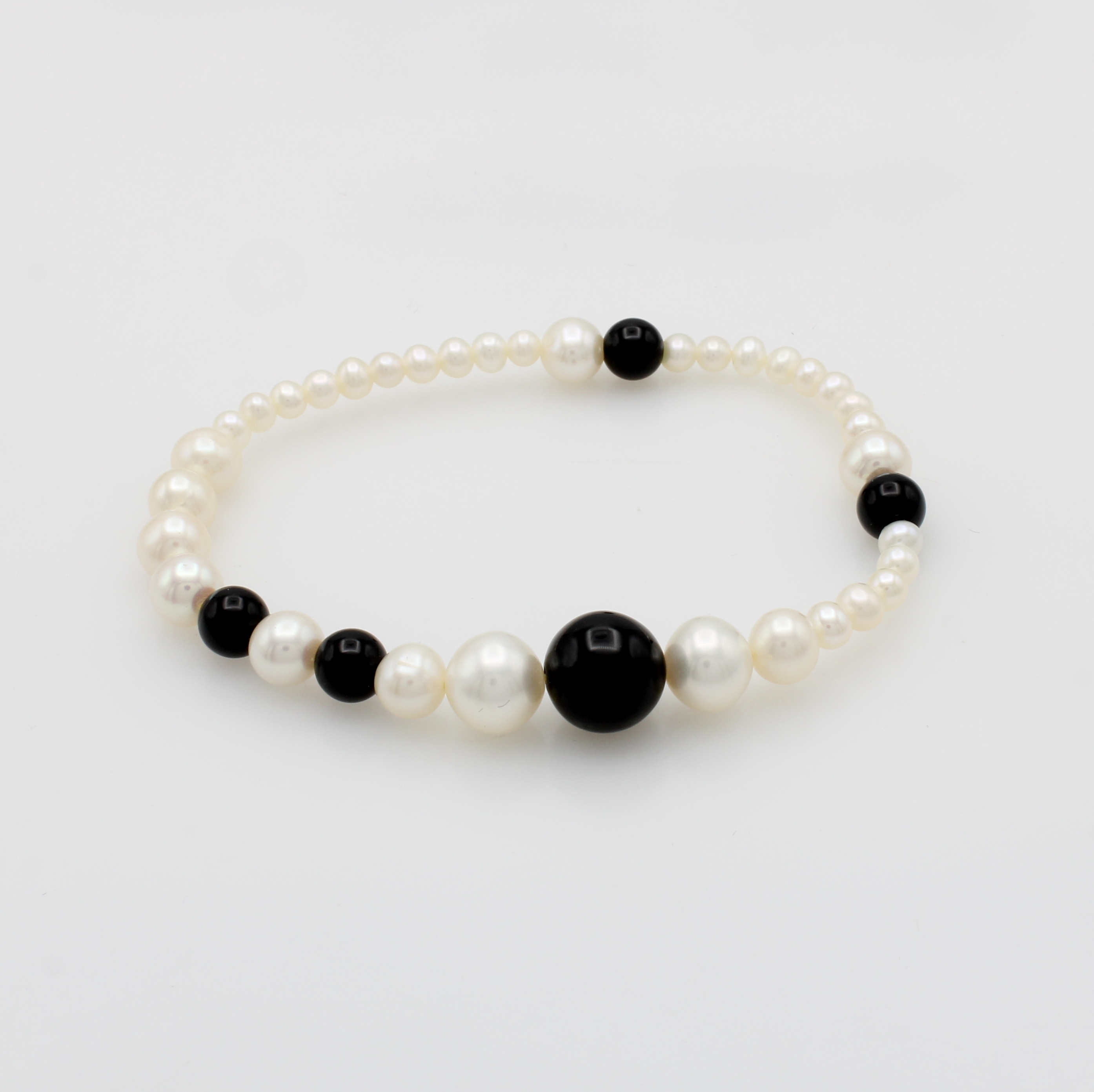 Image 27103713 - Elastisches Süßwasserzuchtperlenarmband mit Onyxen, weiße Perlen, Onyxkugeln