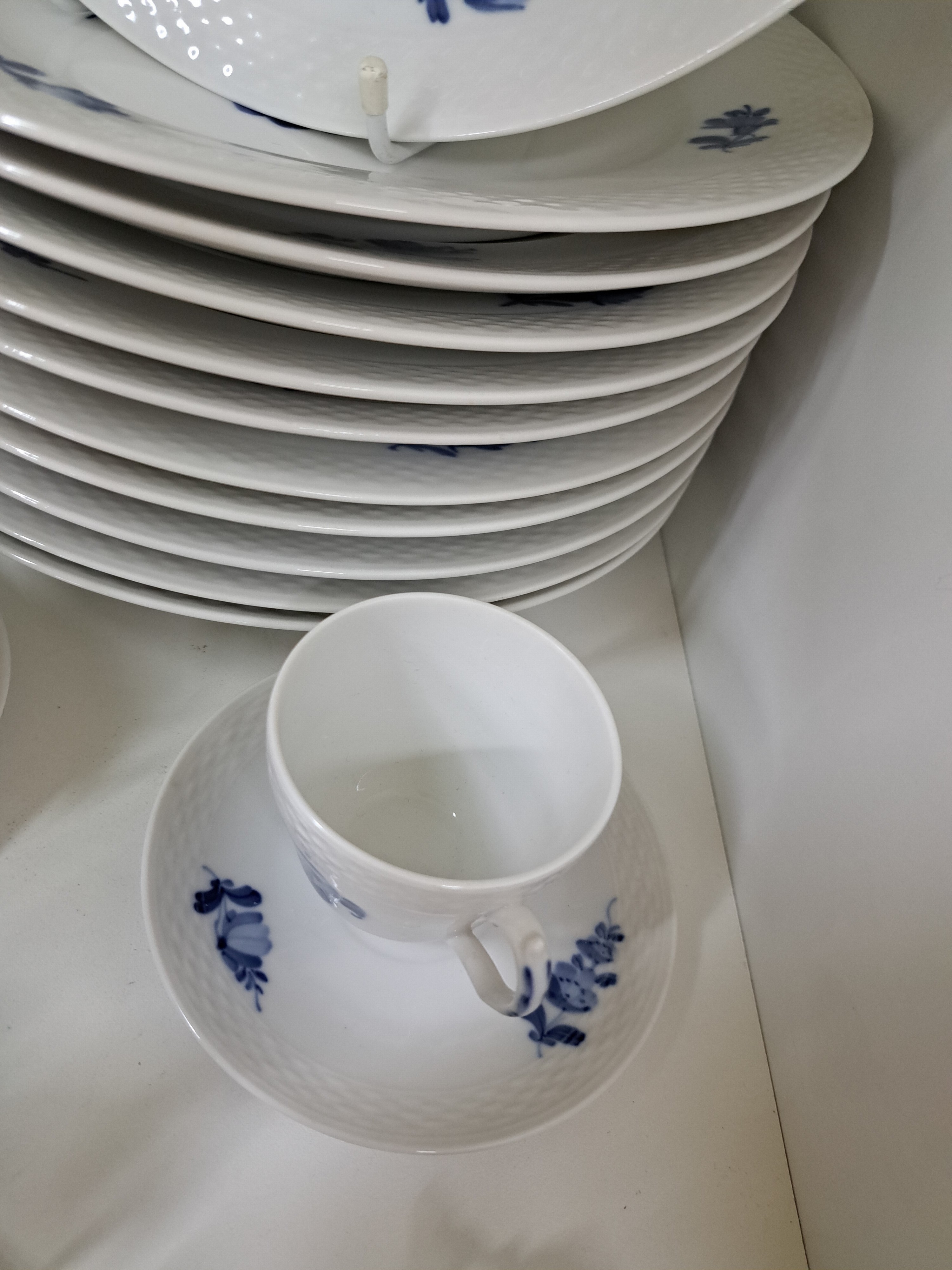 Detail a: 11 flache Teller, Kgl. Kopenhagen, 20. Jh., 2.Wahl, Rand mit Korbrelief, blaue Blumen unter der Glasur, D. je ca. 25.5cm, dazu 3 Mokka- bzw. ...