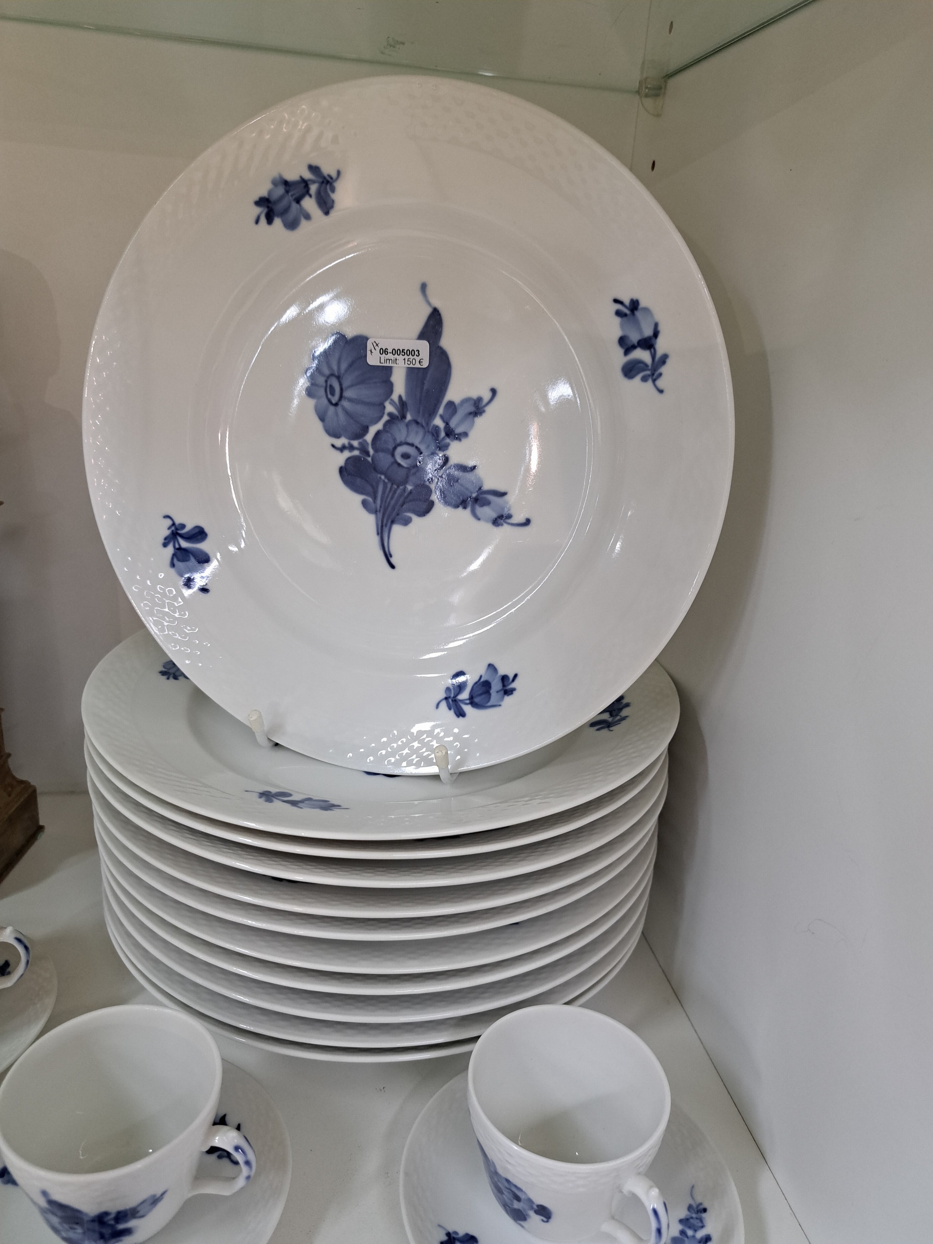 Detail b: 11 flache Teller, Kgl. Kopenhagen, 20. Jh., 2.Wahl, Rand mit Korbrelief, blaue Blumen unter der Glasur, D. je ca. 25.5cm, dazu 3 Mokka- bzw. ...