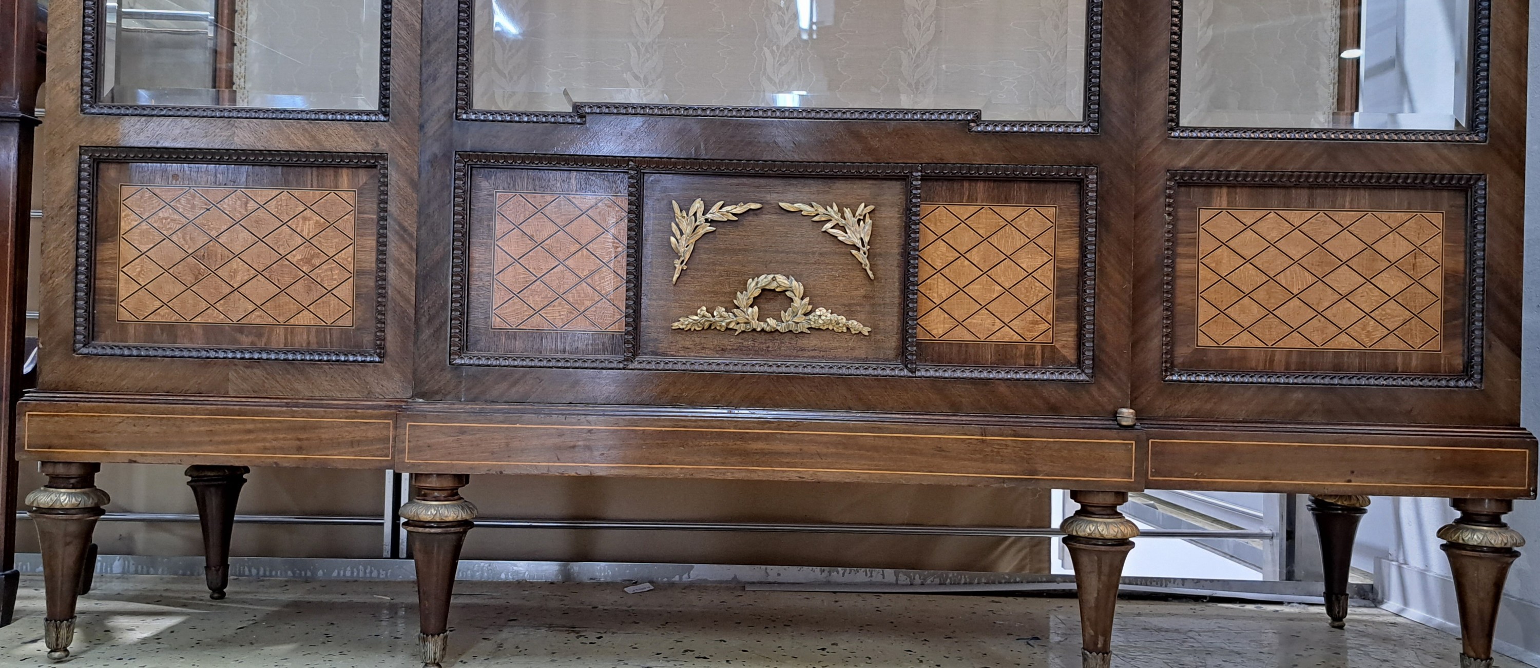 Detail d: Vitrine im Louis-Seize-Stil, um 1900, Mahagonifurnier, feine Bandeinlagen, in den unteren Feldern mit Rautenmarketerie, eintürig, mit 5 facettierten ...