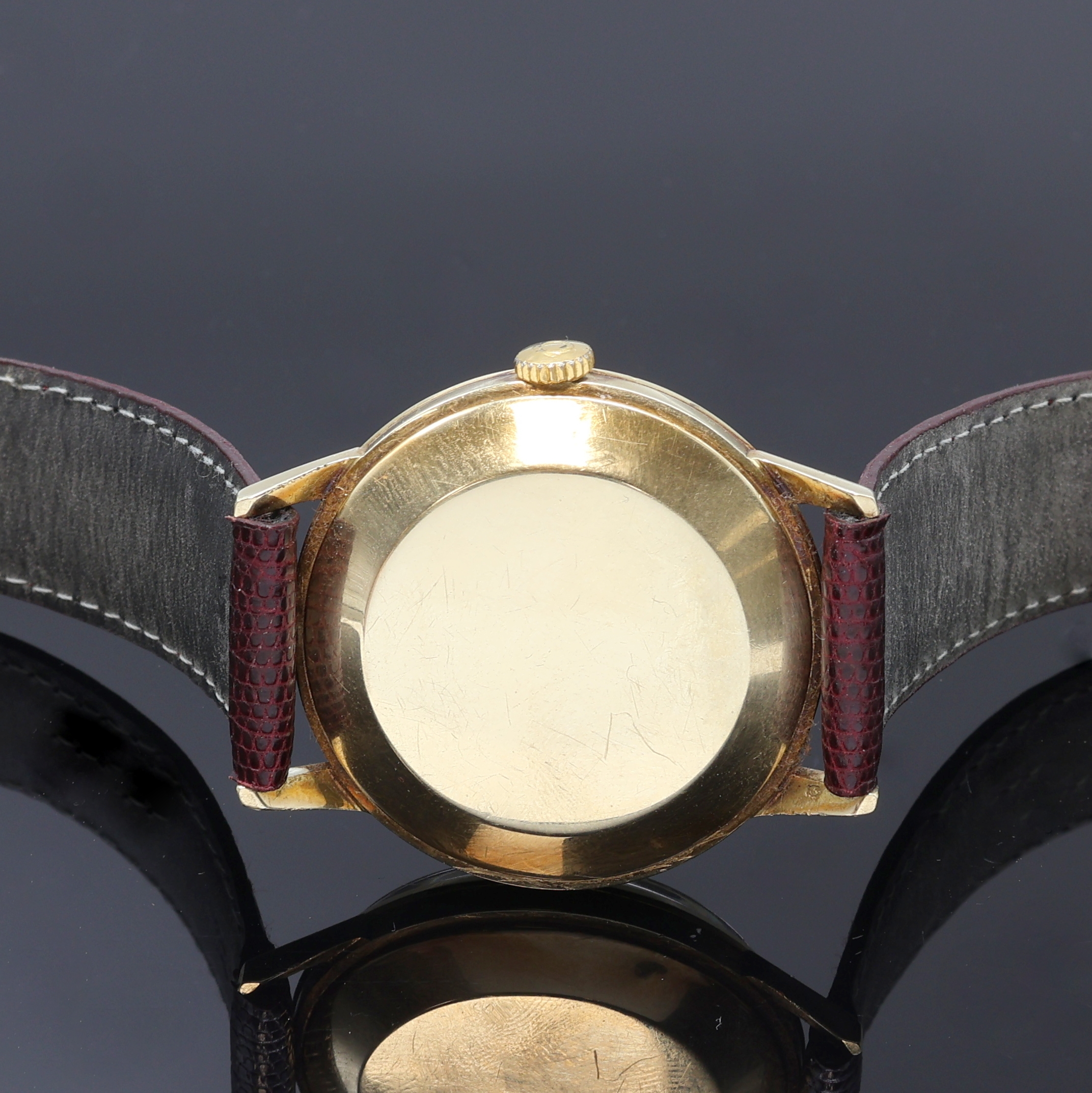 Detail d: OMEGA Herrenarmbanduhr in GG 585/000 Referenz 14720 1, Schweiz um 1961, Handaufzug, Boden (dell.) u. Glasrand aufgedr., neutr. Lederband m. orig. ...