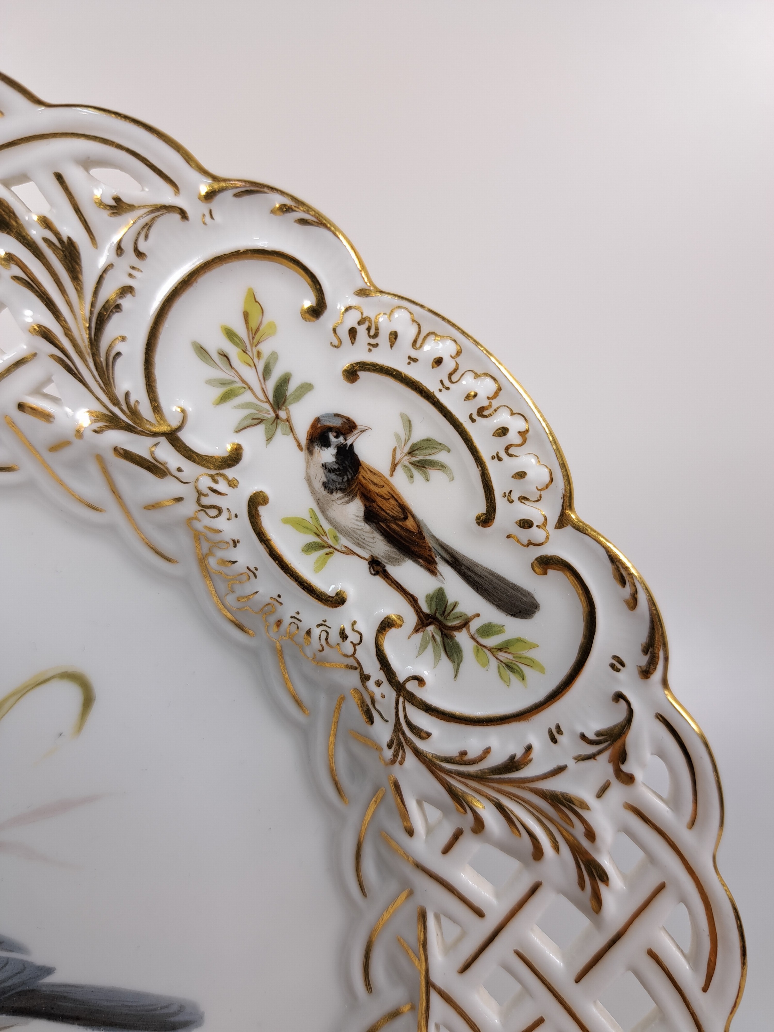 Detail c: Paar Zierteller/Dessertteller, Meissen, um 1880/90, Porzellan, Wandung in Durchbrucharbeit, Goldstaffage, feine Vogelbemalung, in drei Kartuschen ...
