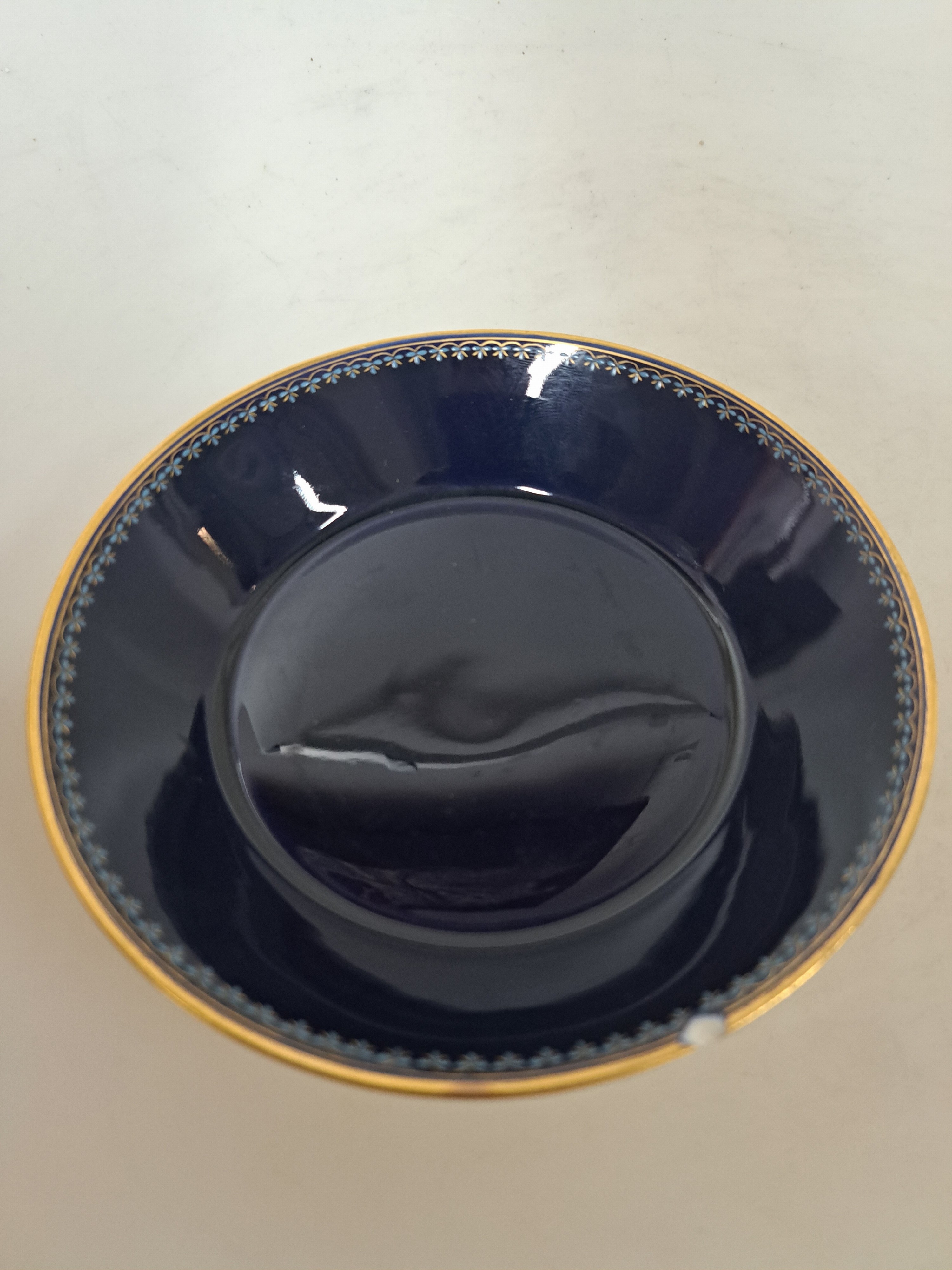 Detail b: Kaffeetasse mit Untertasse, Meissen, Knaufzeit, Porzellan, königsblauer Fond, Tasse mit Pate sur Pate-Dekor Putto mit Vögeln, UT mit Chip, ...