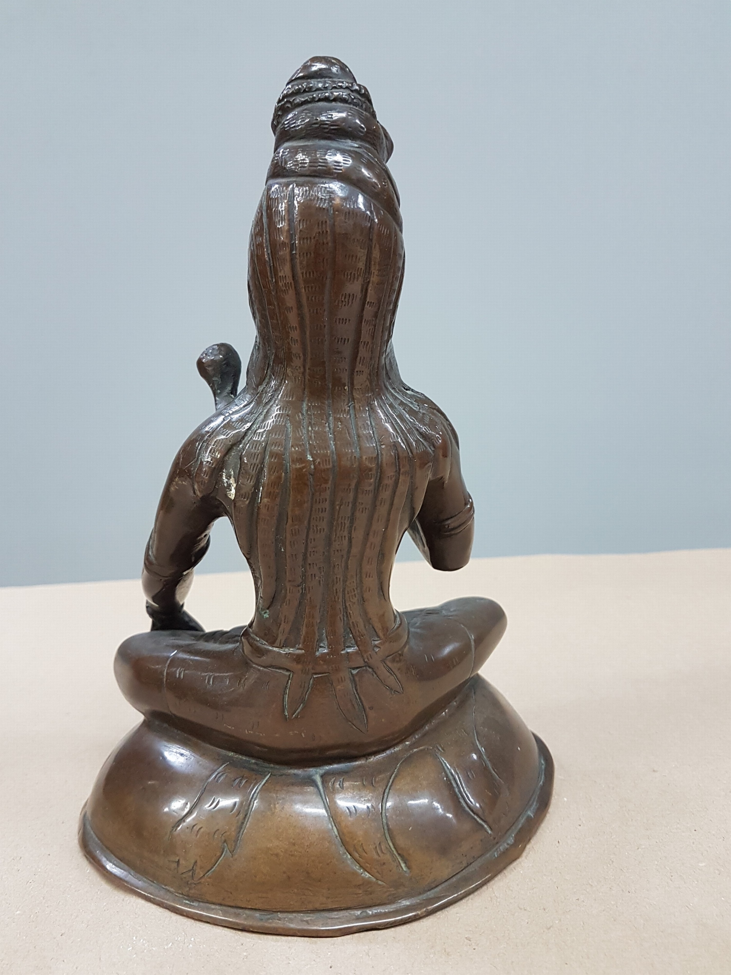 Detail c: Bronzefigur/Shiva, Indien, wohl 19. Jh., patiniert, mit Schlange um den Hals, auf einem Löwenfell sitzend, H. ca. 21 cm